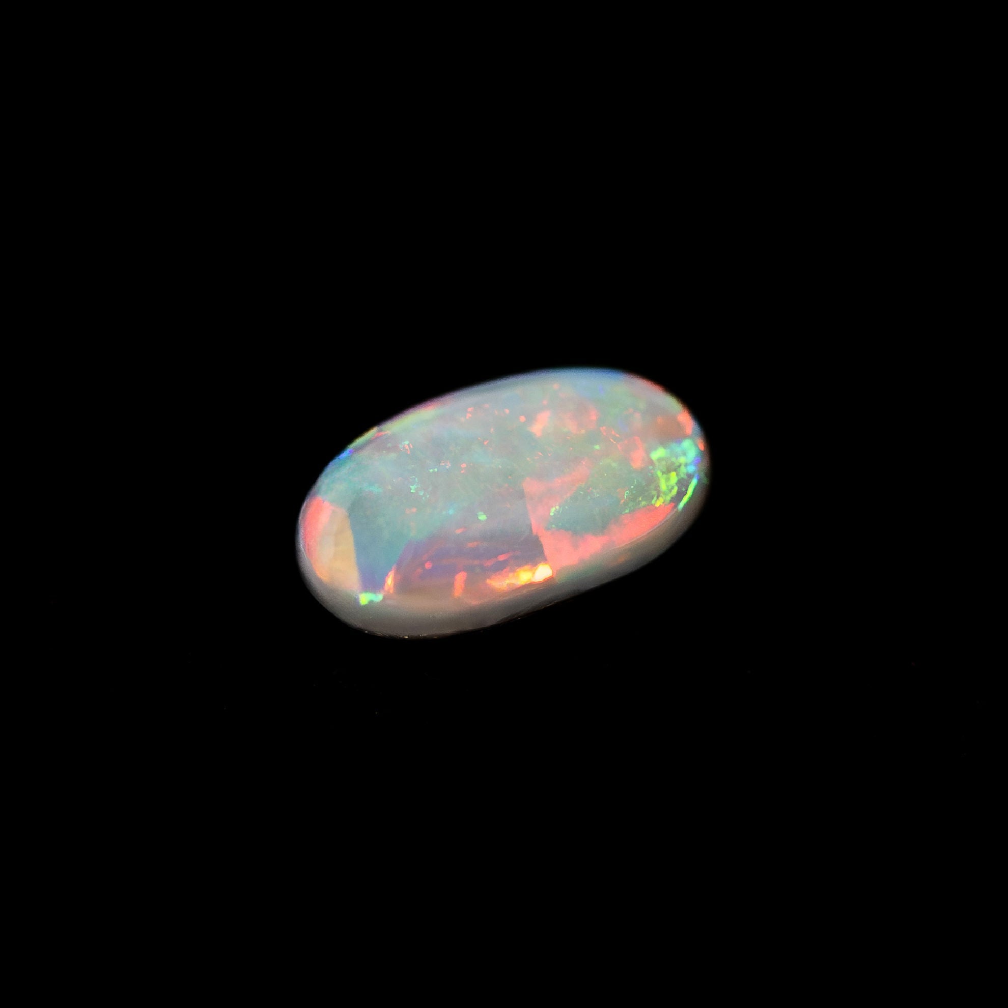 Australian black Multi-colored opal stone on a black background