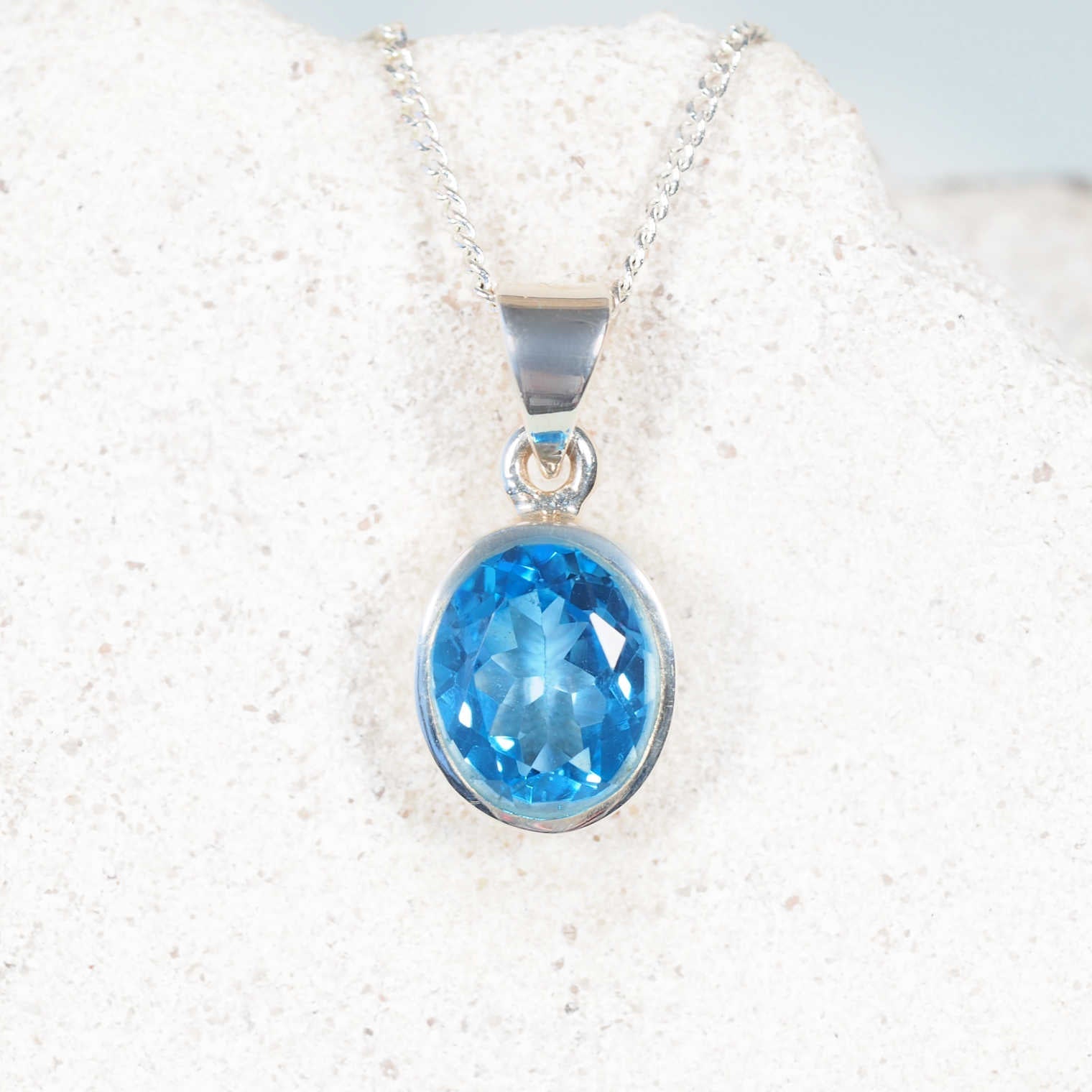 The 'Lilli' Blue Topaz pendant with petite circular faceted gemstone set in a polished silver bezel, showing bright blue sparkle