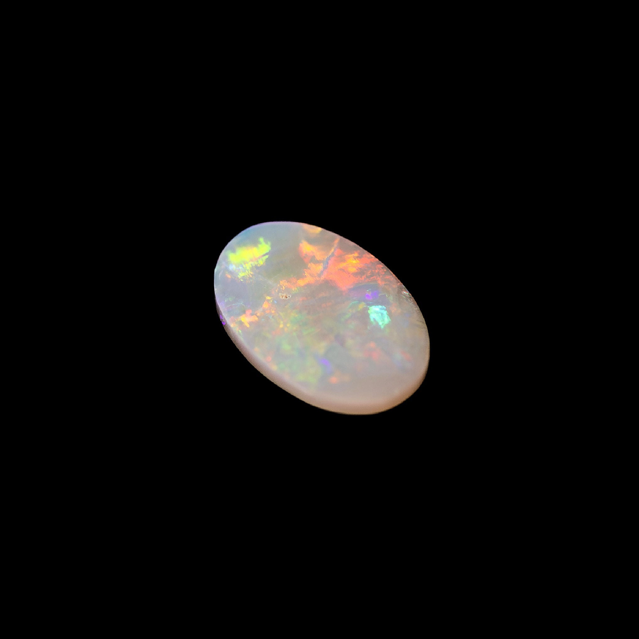 natural crystal opal with bursts of electric colour and smooth oval shape, ethically sourced from Lightning Ridge