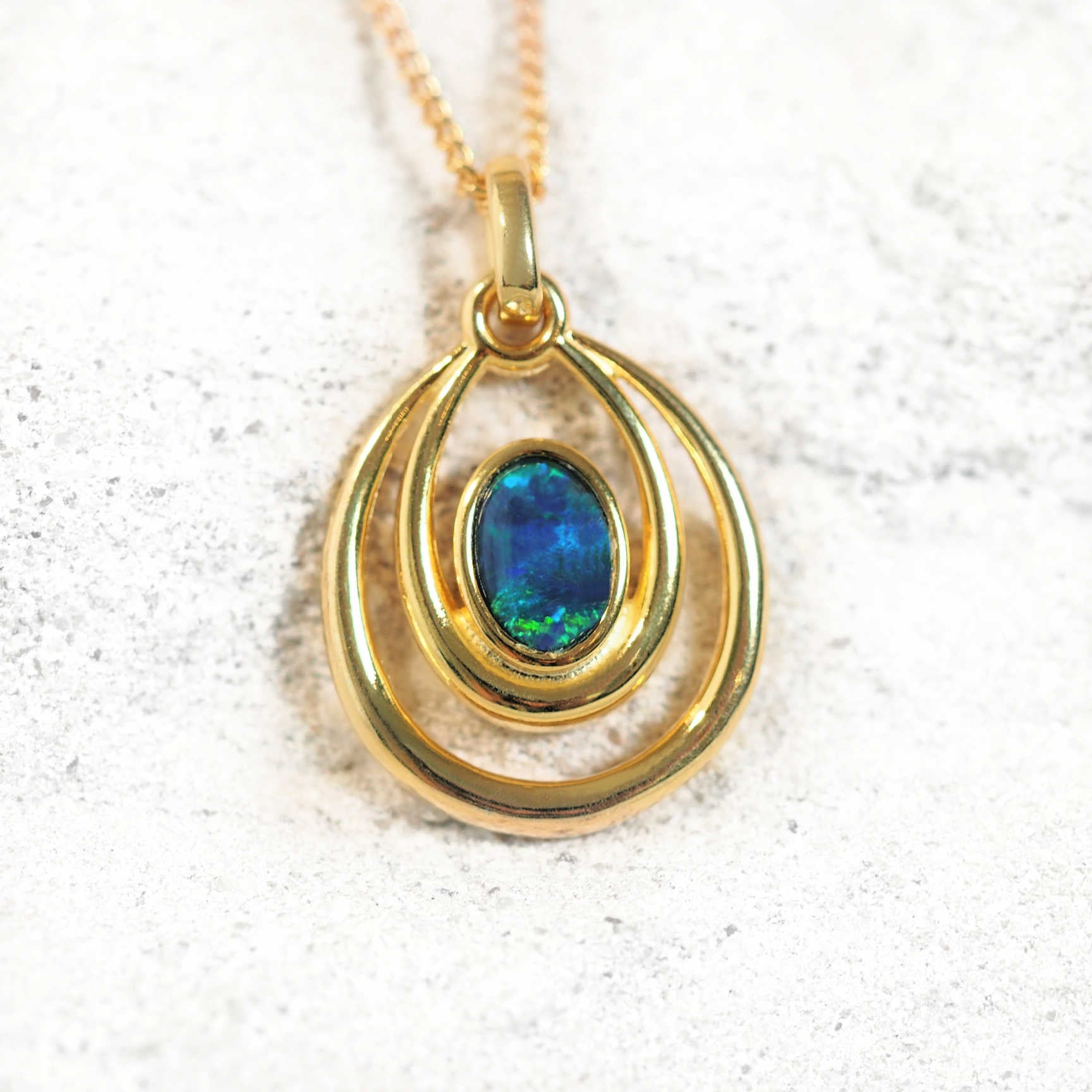 Gold-plated silver opal pendant necklace with blue-green Australian triplet opal in a double ring bezel setting on matching chain.