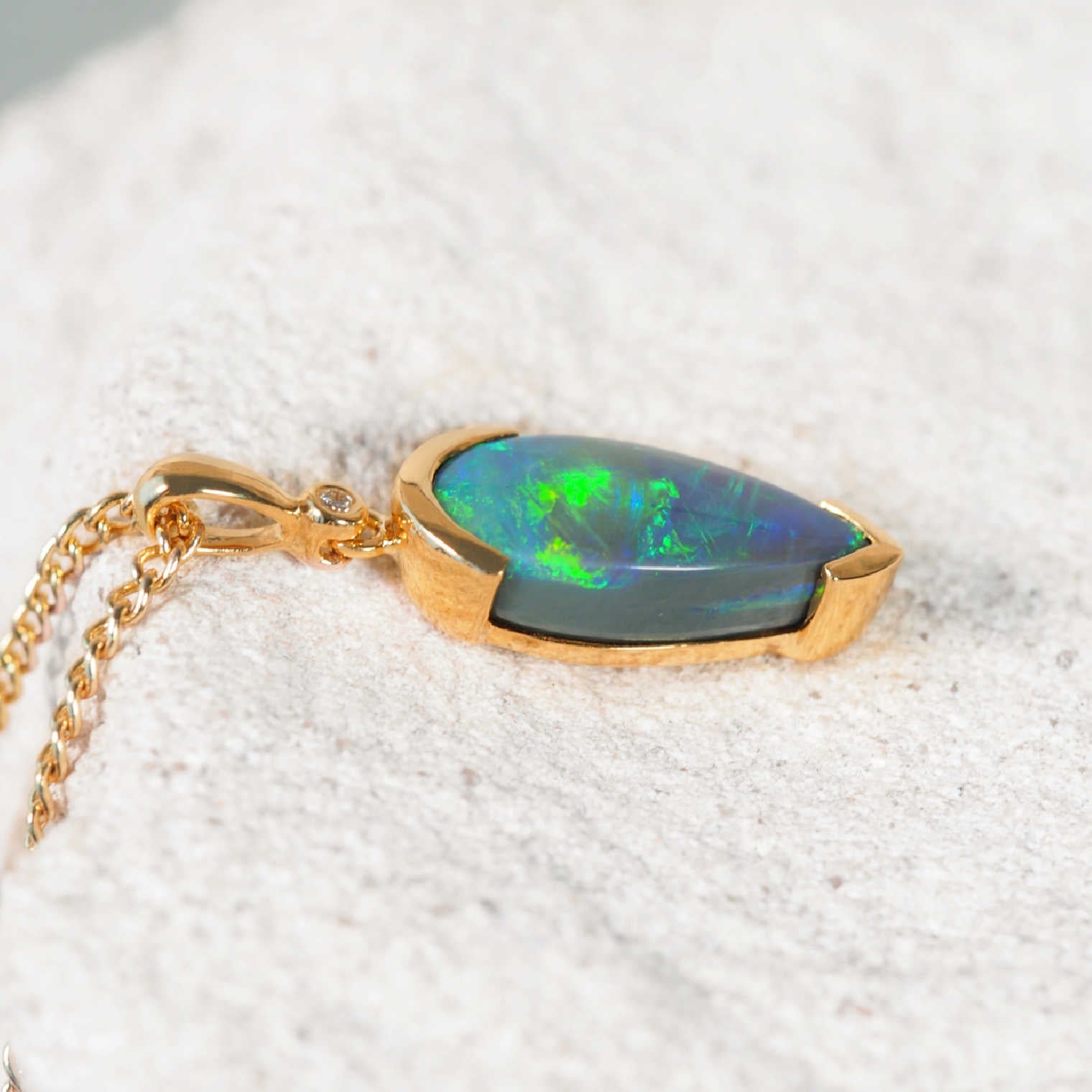 Bezel-set 18ct gold black opal necklace with shimmering green and blue opal and diamond by Black Star Opal