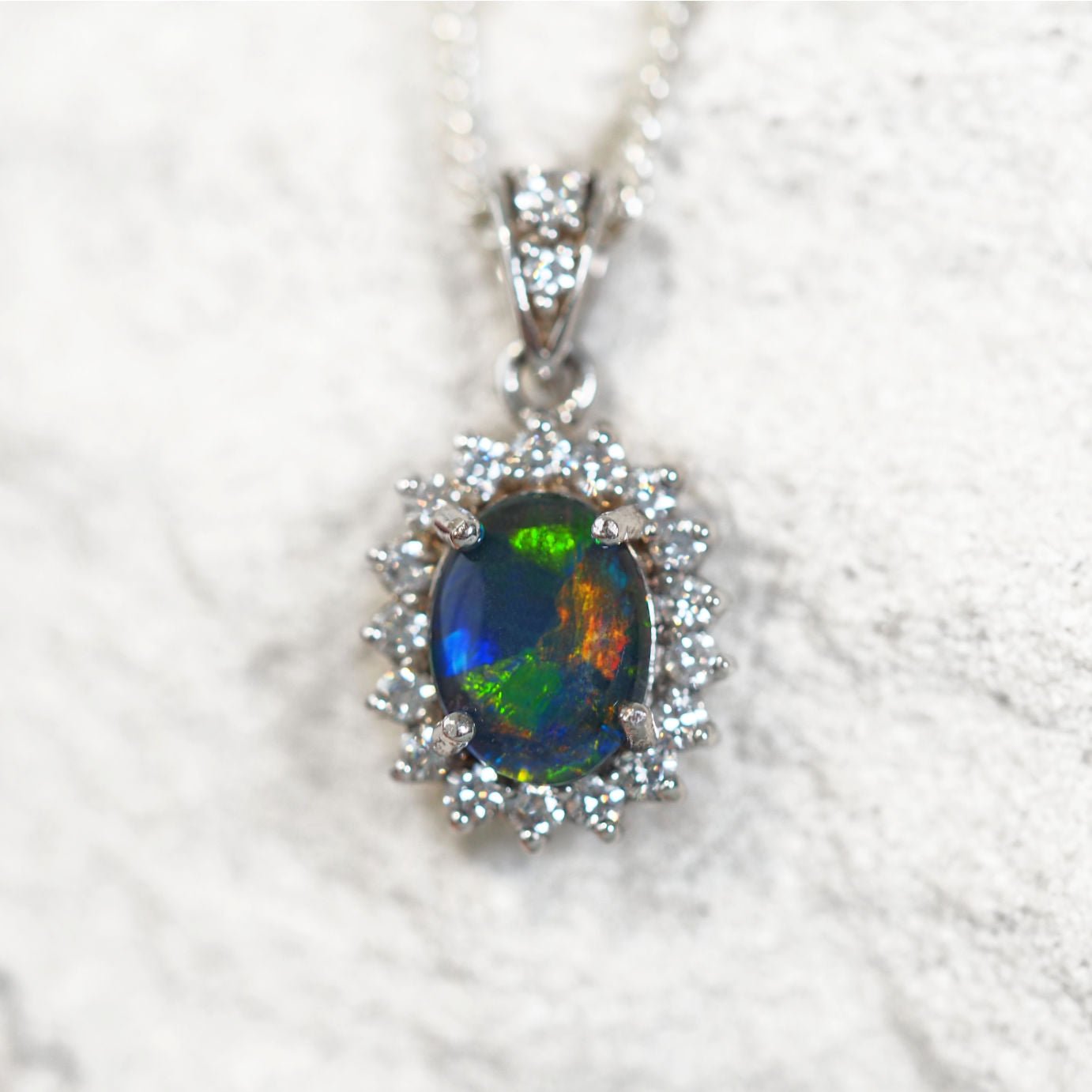 'Lumina' opal pendant in sterling silver with claw-set oval Australian triplet opal and halo of 17 diamantés plus diamanté-accented bale