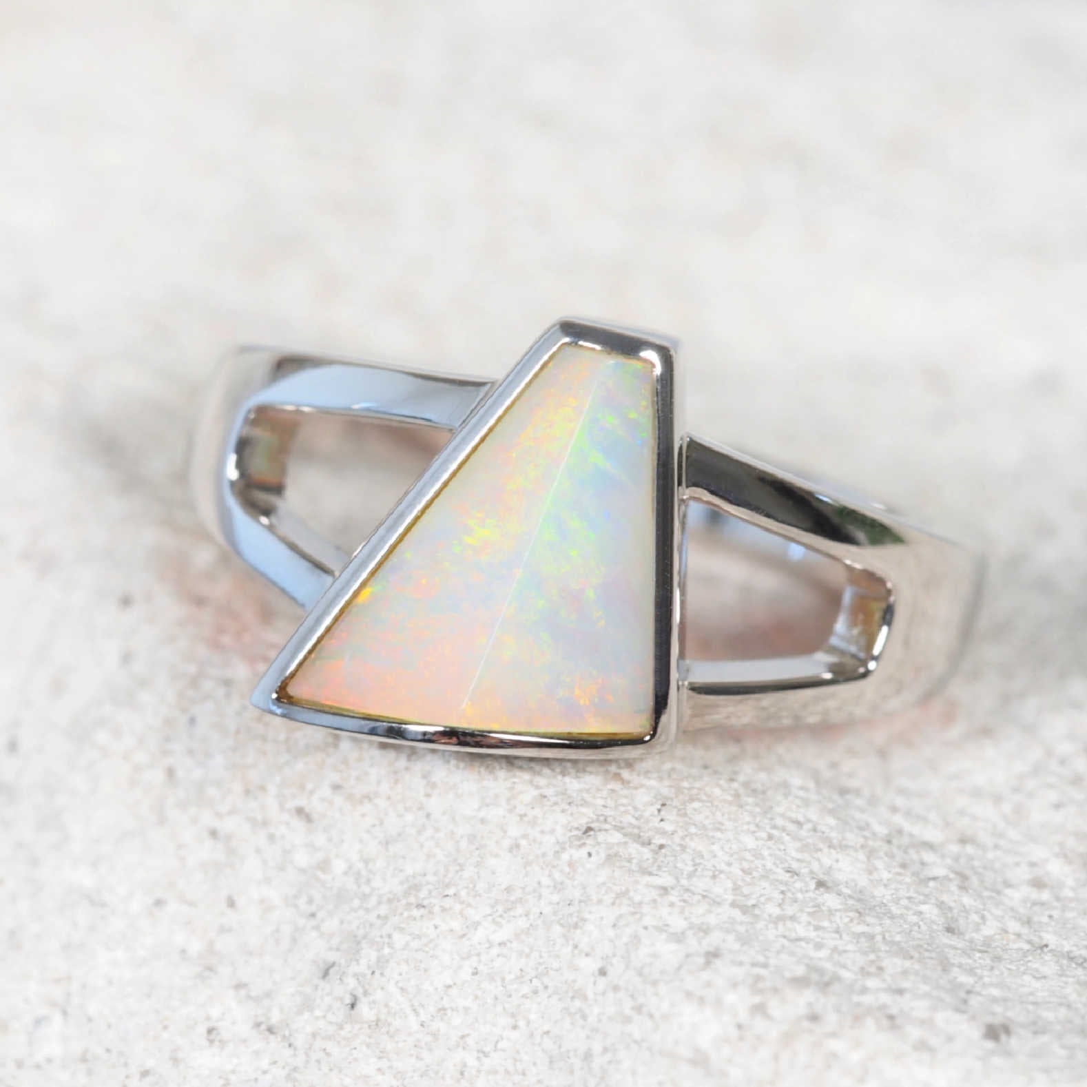 Triangular solid white opal ring with rainbow flashes