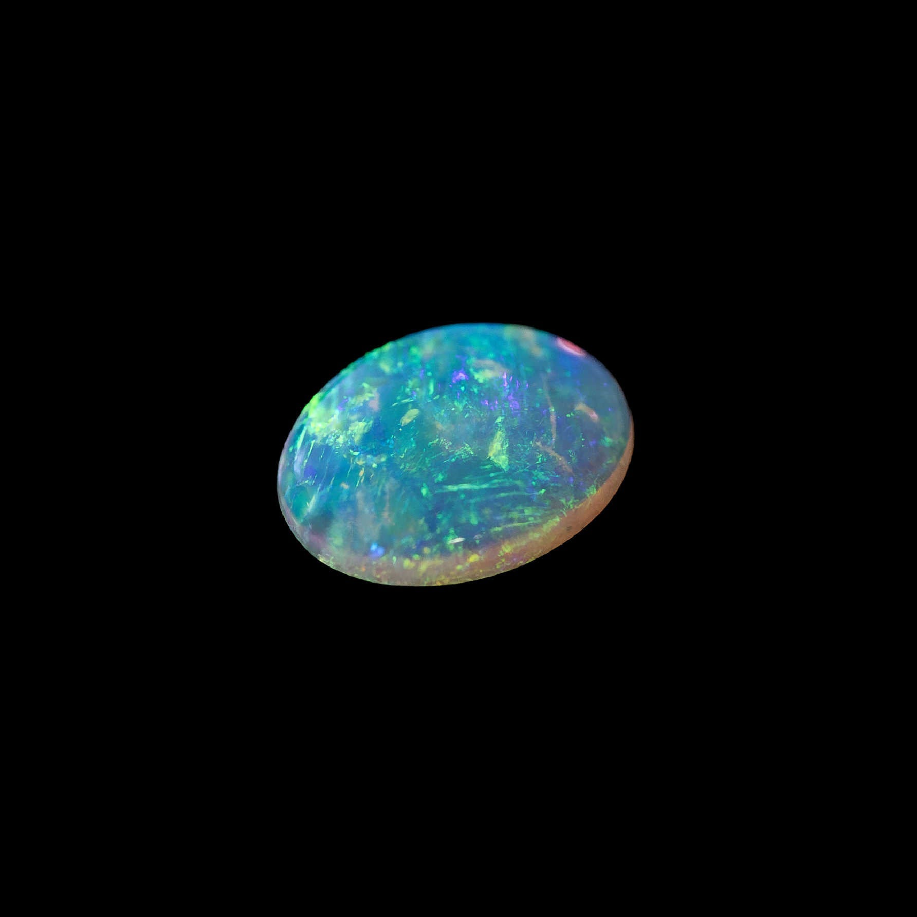 Green Australian crystal opal stone on a black background