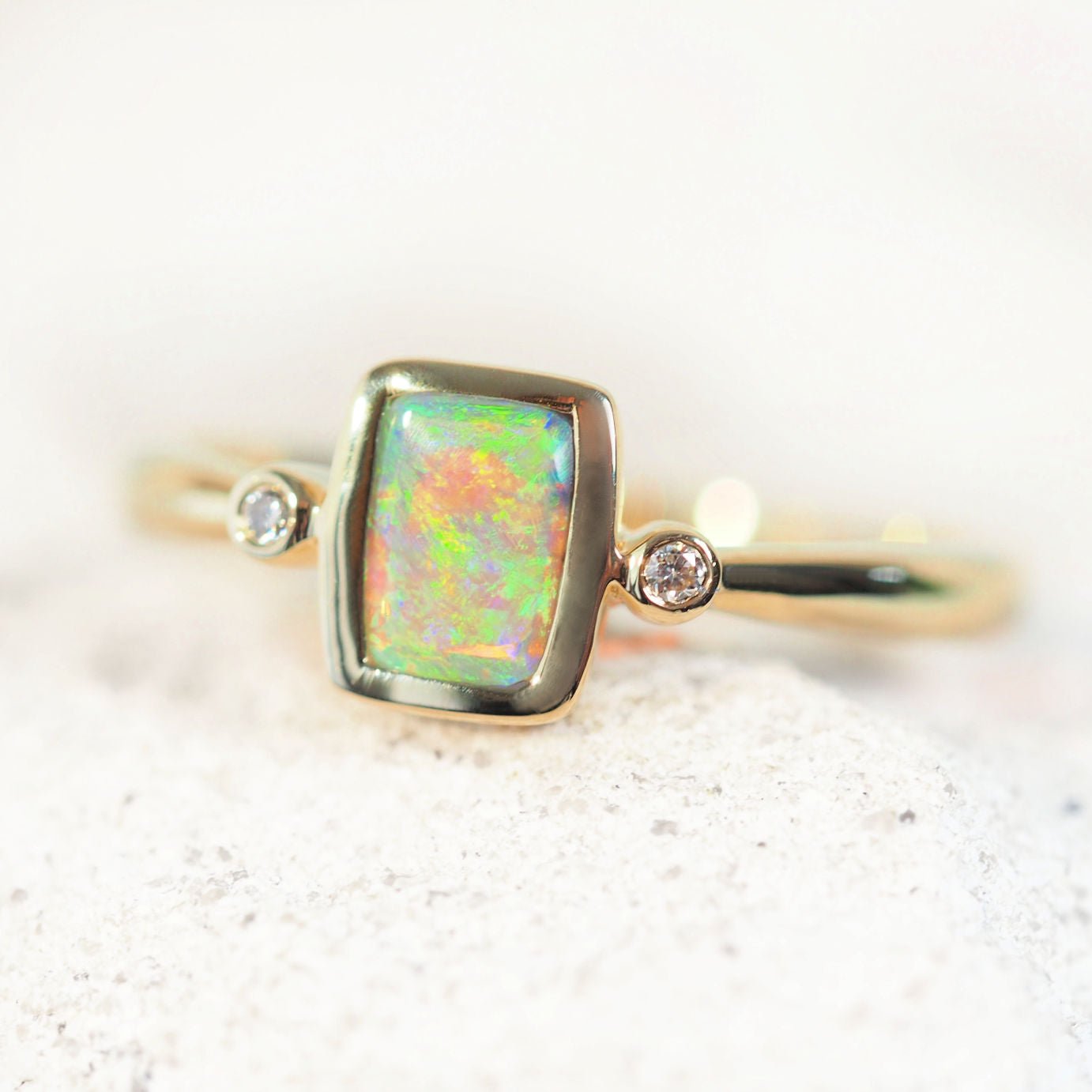 Australian opal ring featuring rectangular green crystal opal and two shoulder-set diamonds