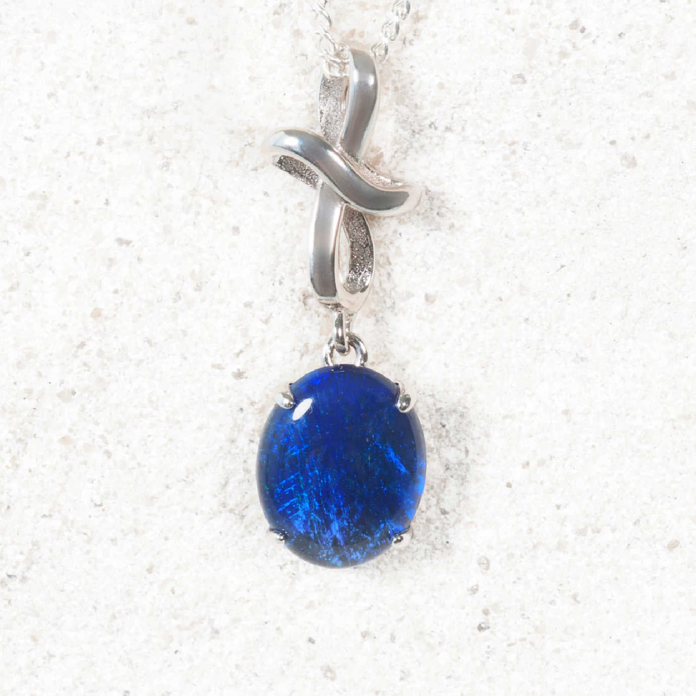 Silver pendant with a blue opal gemstone on a white background