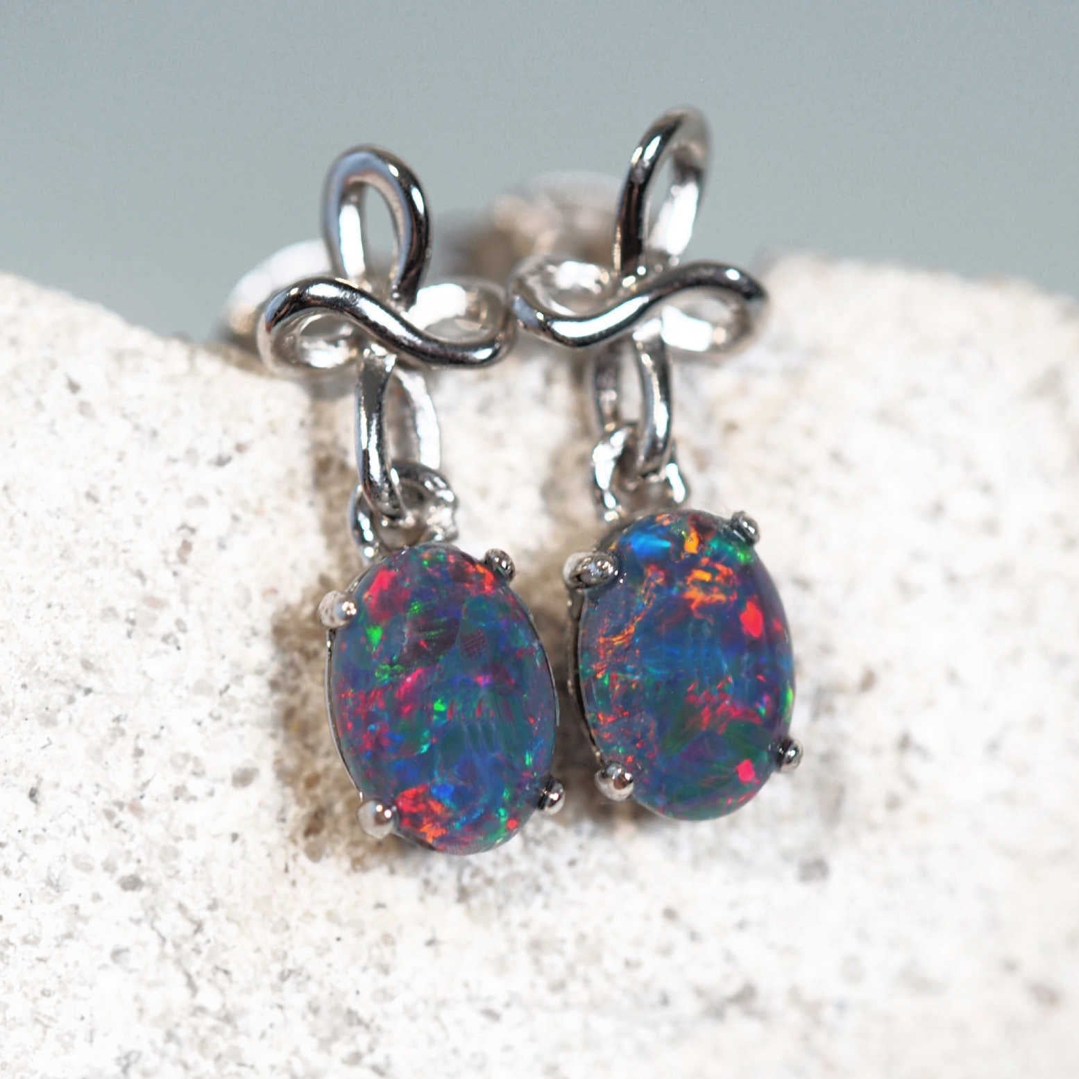 colourful opal earrings set in sterling silver with a decorative twist