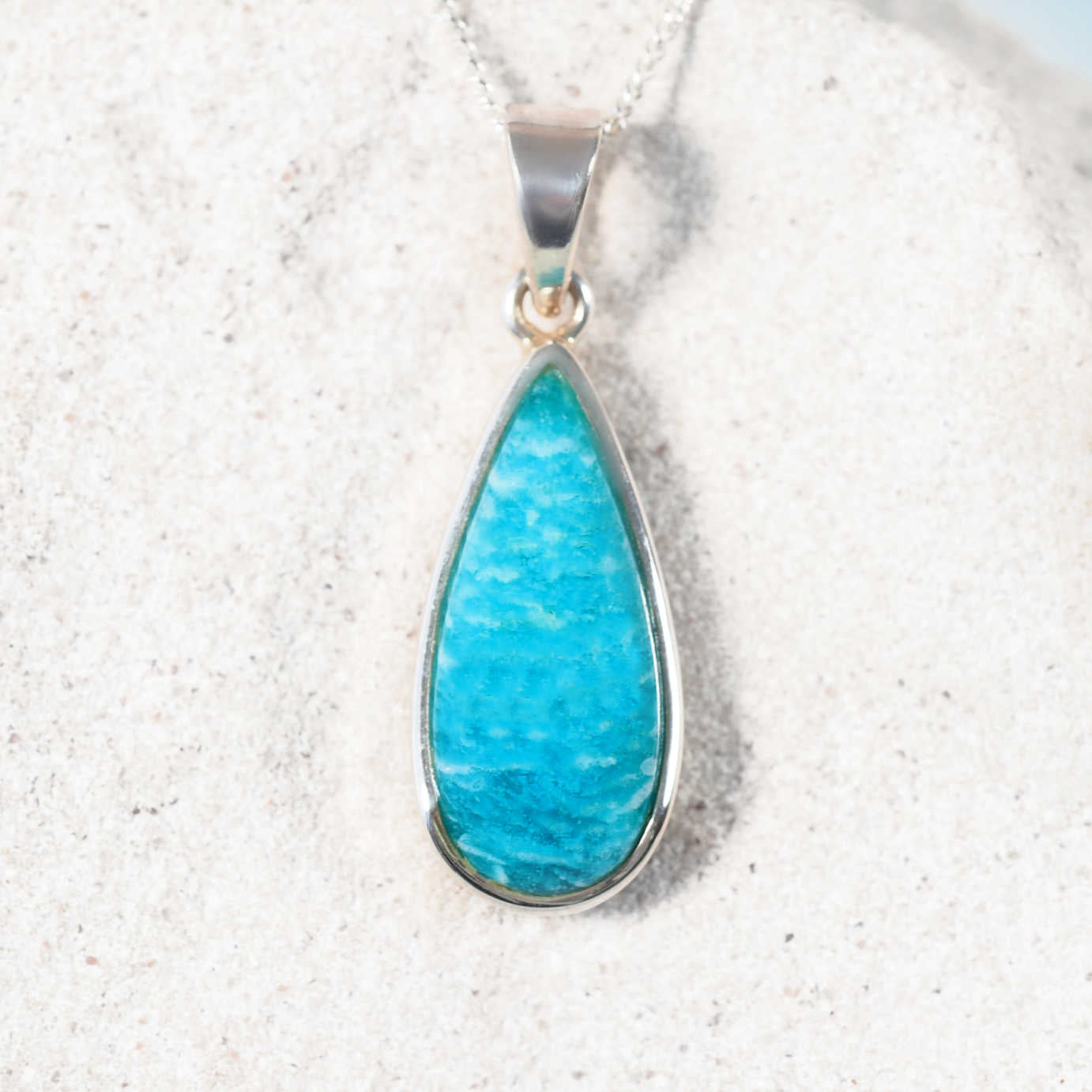The 'Nina' Amazonite pendant with teardrop cabochon in polished silver, showing soothing blue-green gemstone