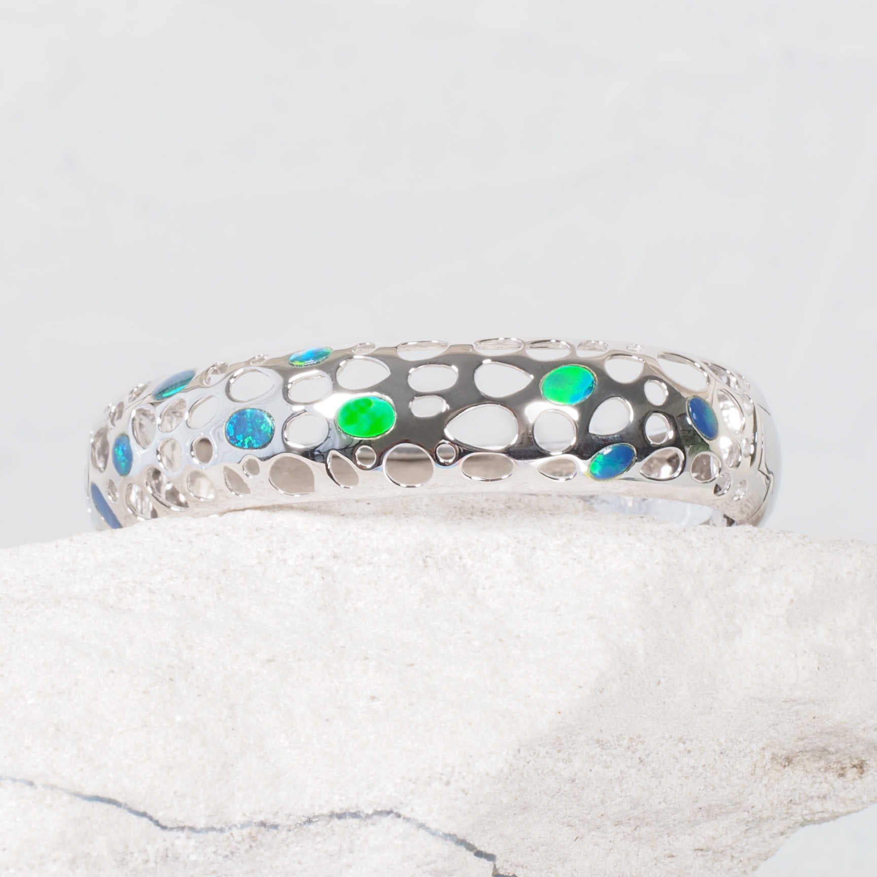 Close-up of inlaid Australian doublet opals with electric blue and green colour – ‘Nova’ bangle