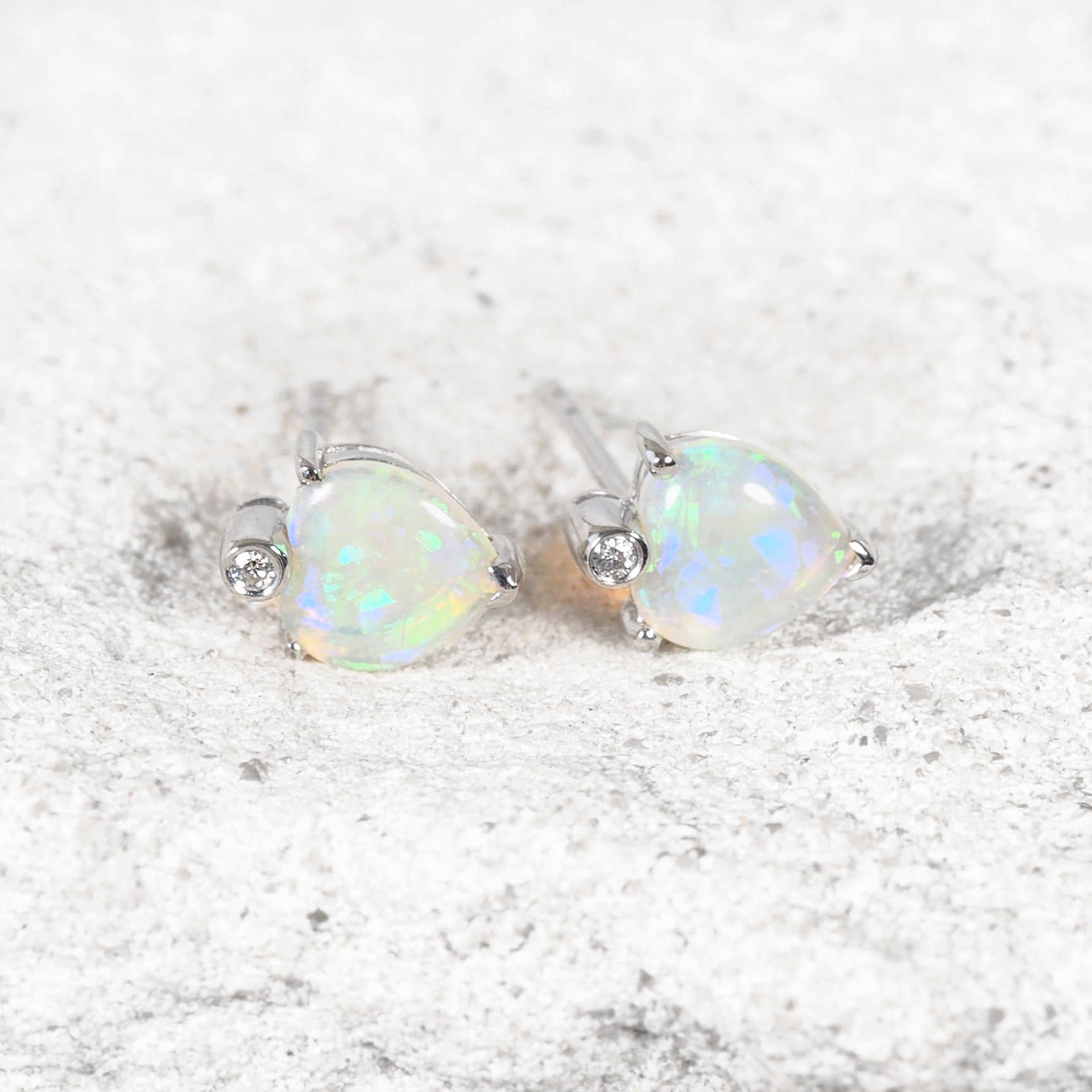 Elegant Australian opal earrings with bezel-set diamonds in white gold, displayed on a jewellery box