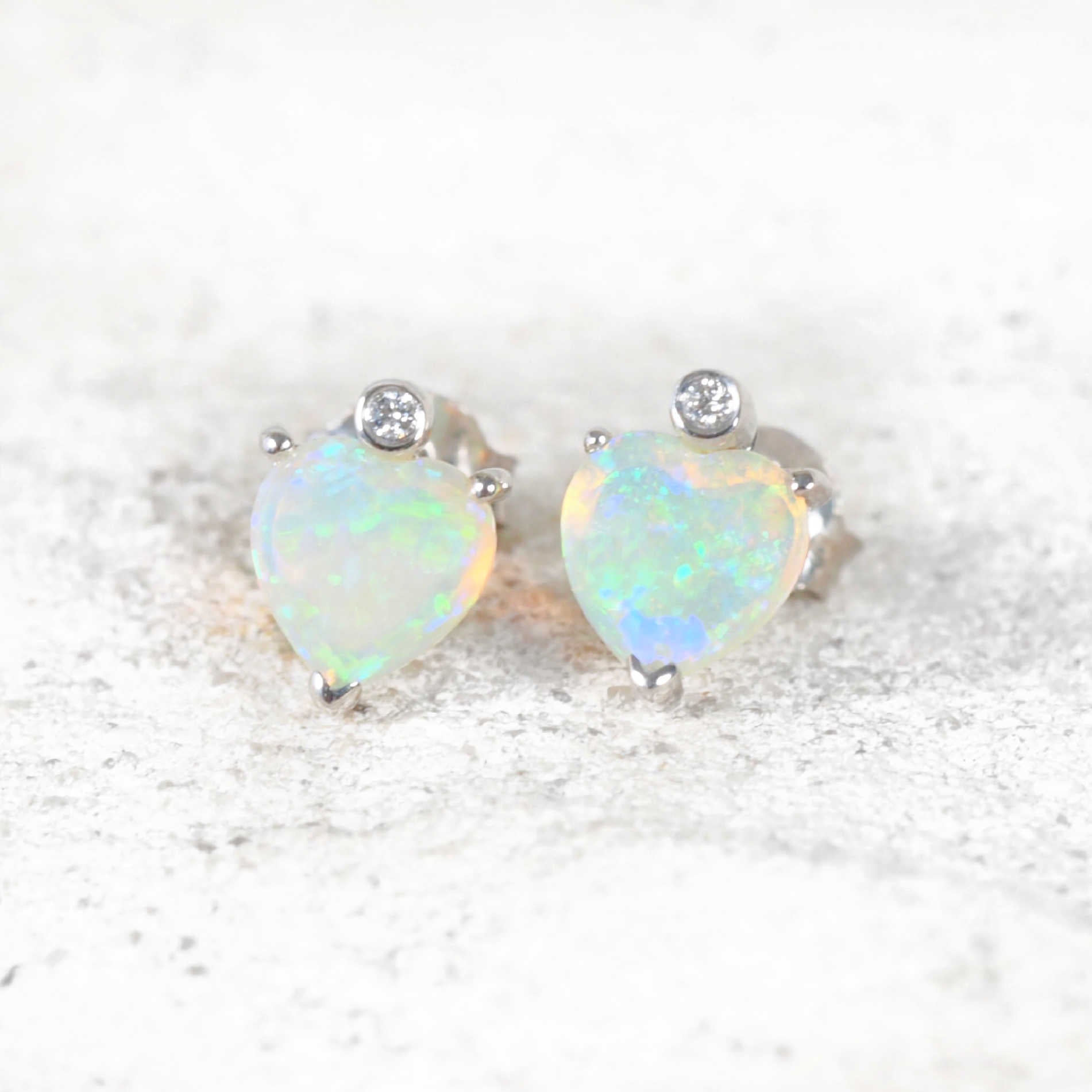 Heart-shaped crystal opal earrings in 14ct white gold with green-blue hues and diamond accents