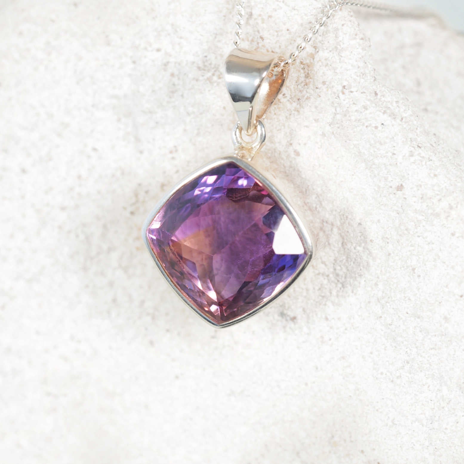 Faceted Amethyst Pendant with Silver framing on a silver display chain