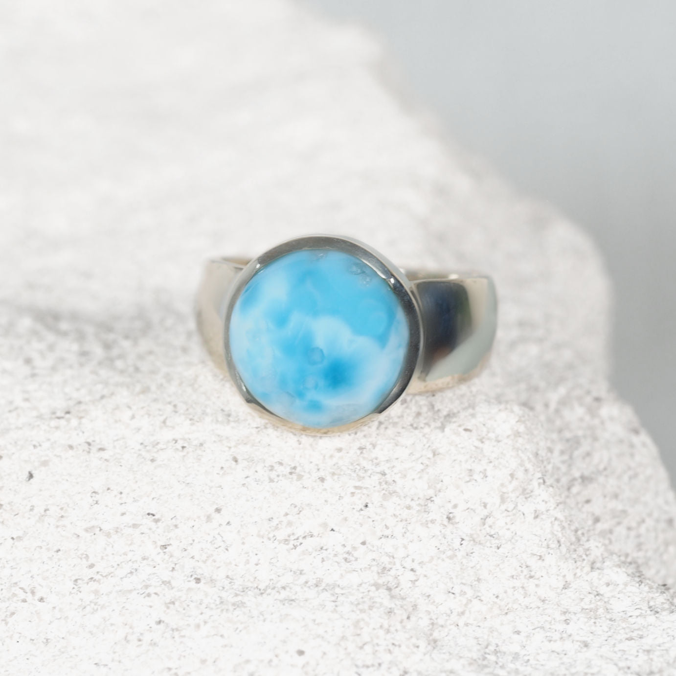 Elegant silver ring, ‘Phoebe,’ showcasing a polished round Larimar gemstone with natural ocean-inspired hues