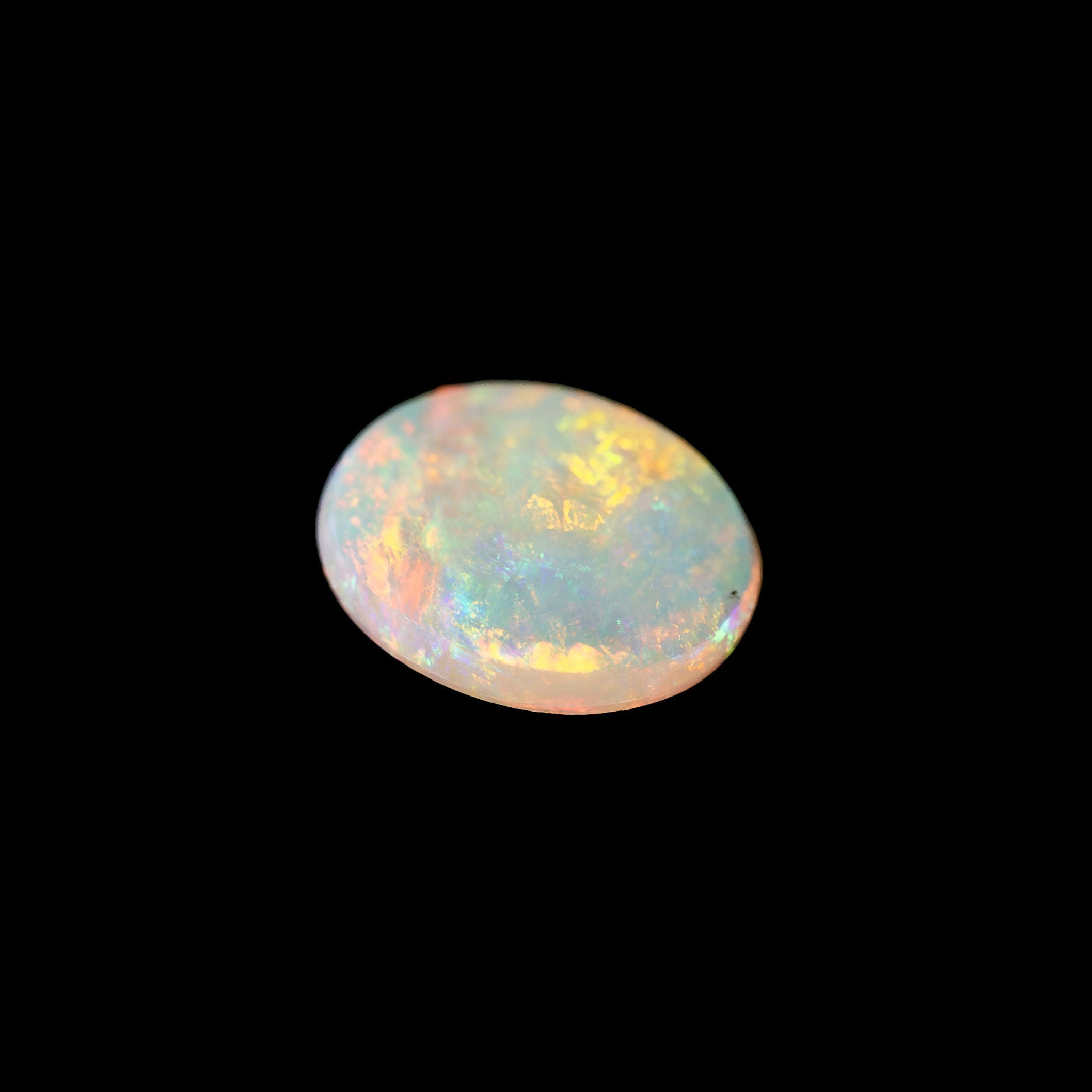 Opal stone with multicolor play of light on a black background