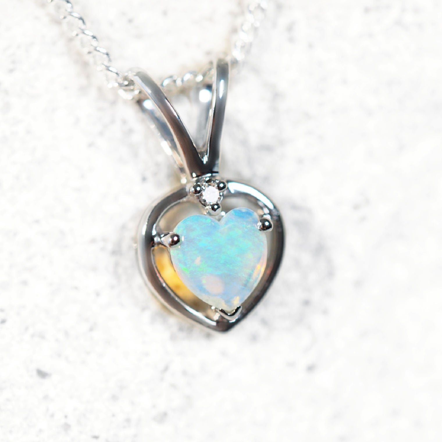 Heart-shaped opal pendant on a white background
