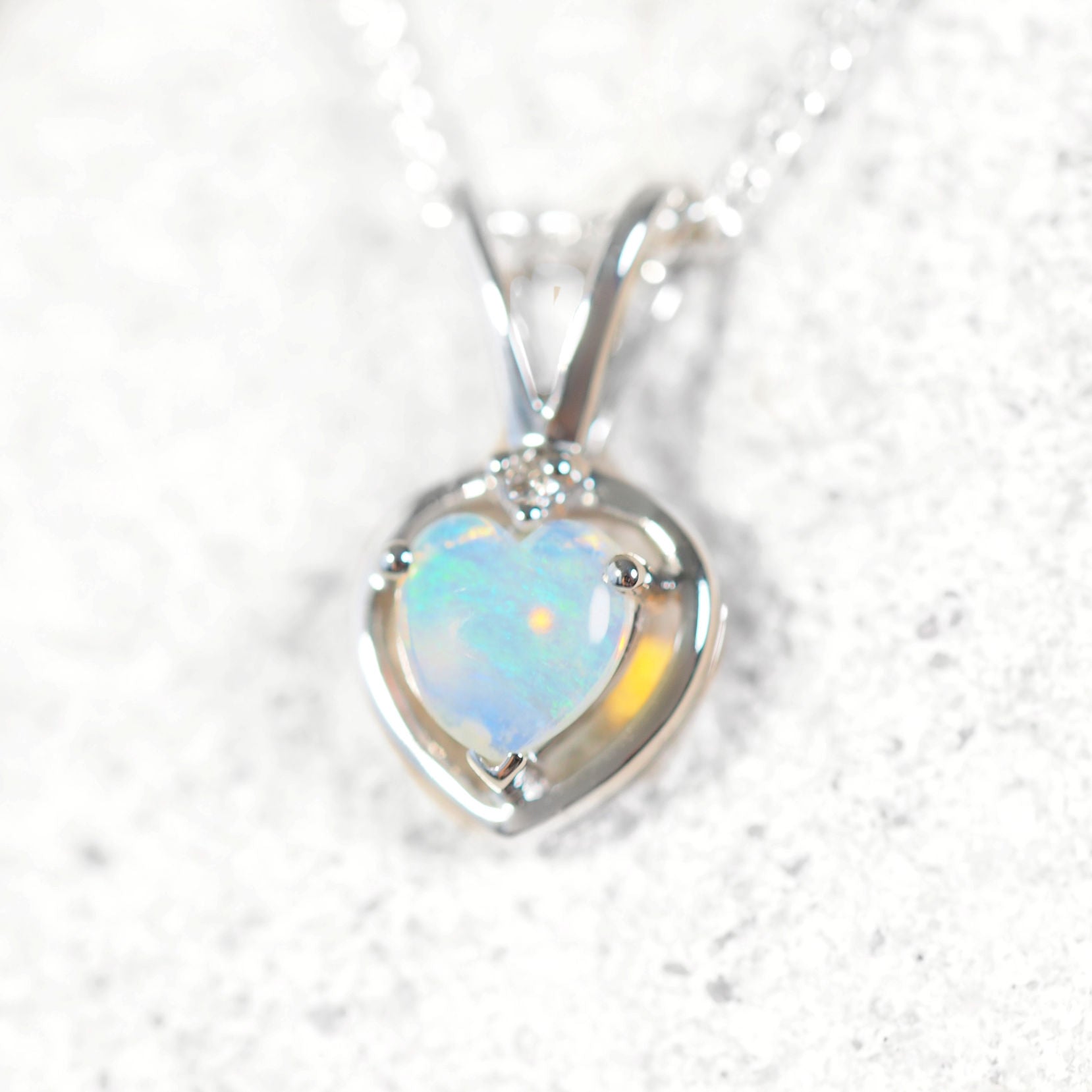 Heart-shaped green opal pendant on a white background