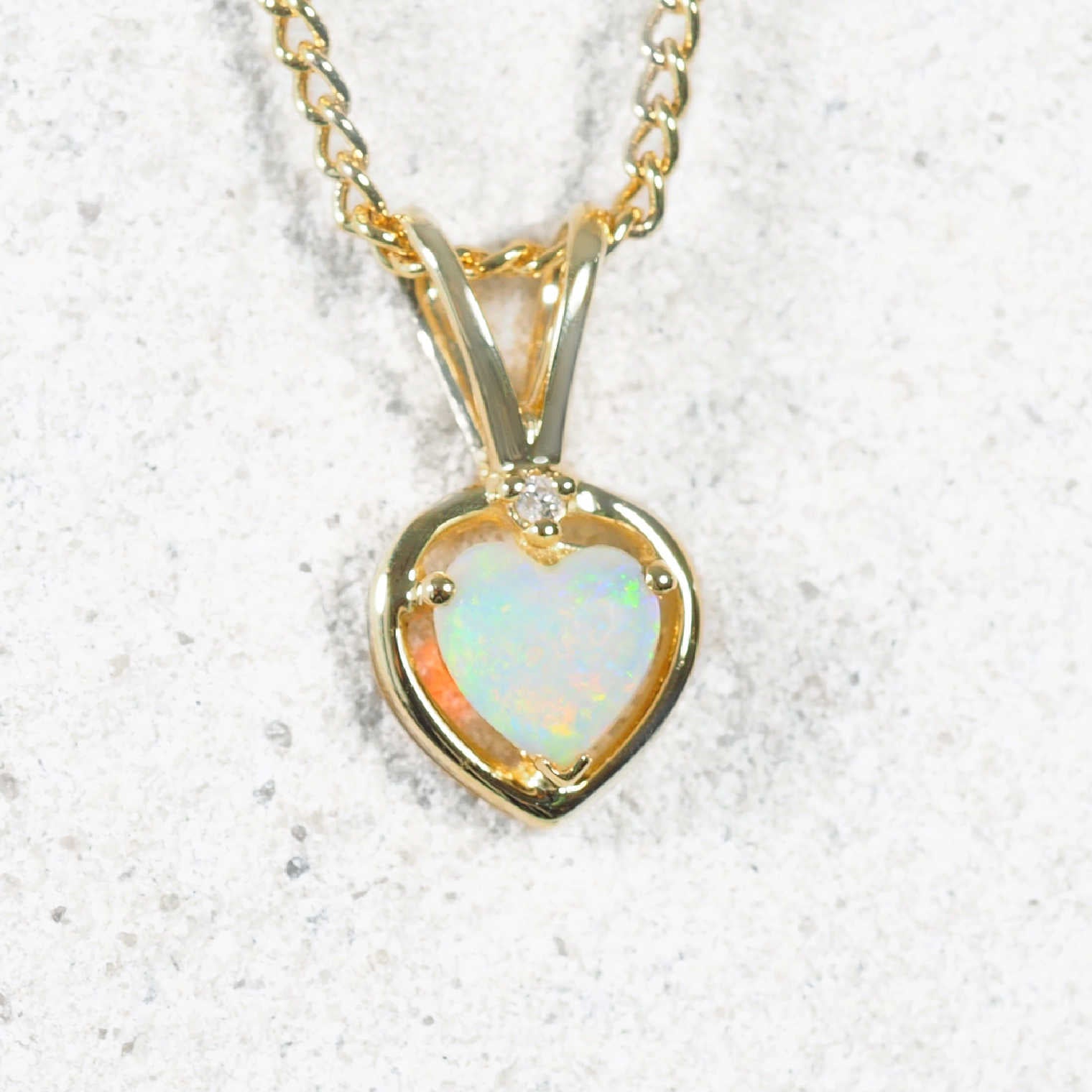 Australian gold necklace with a heart-shaped opal pendant on a white background