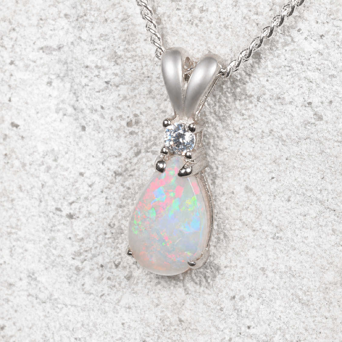 White opal pendant necklace on a textured white background