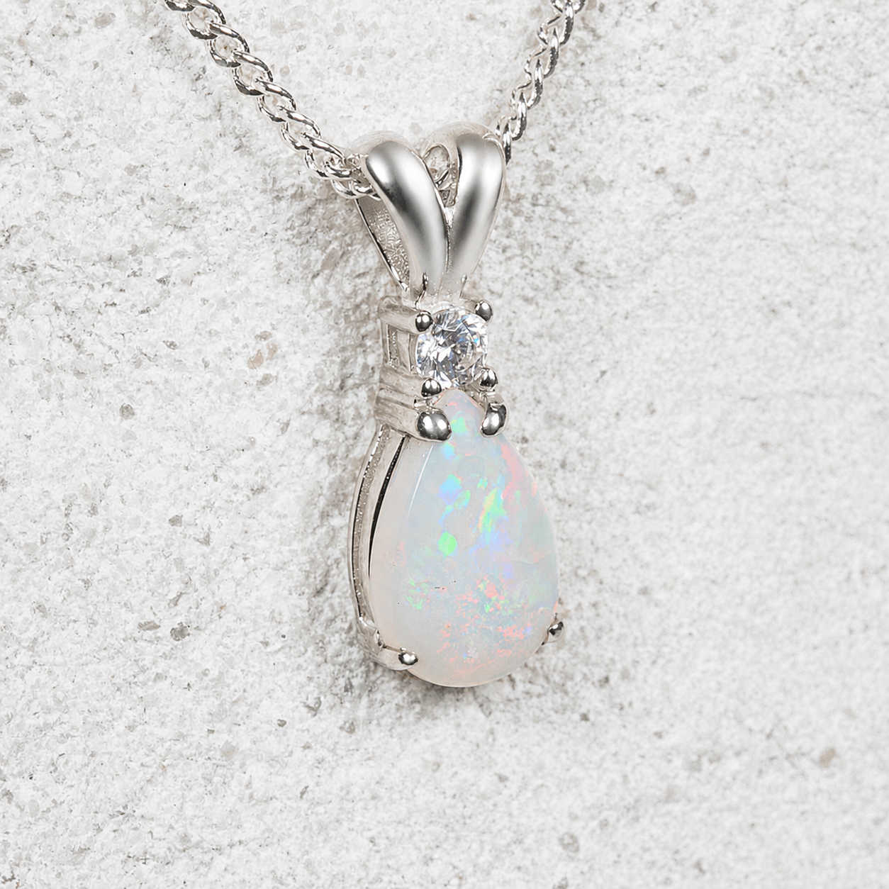Opal pendant necklace with a diamante on a textured white background