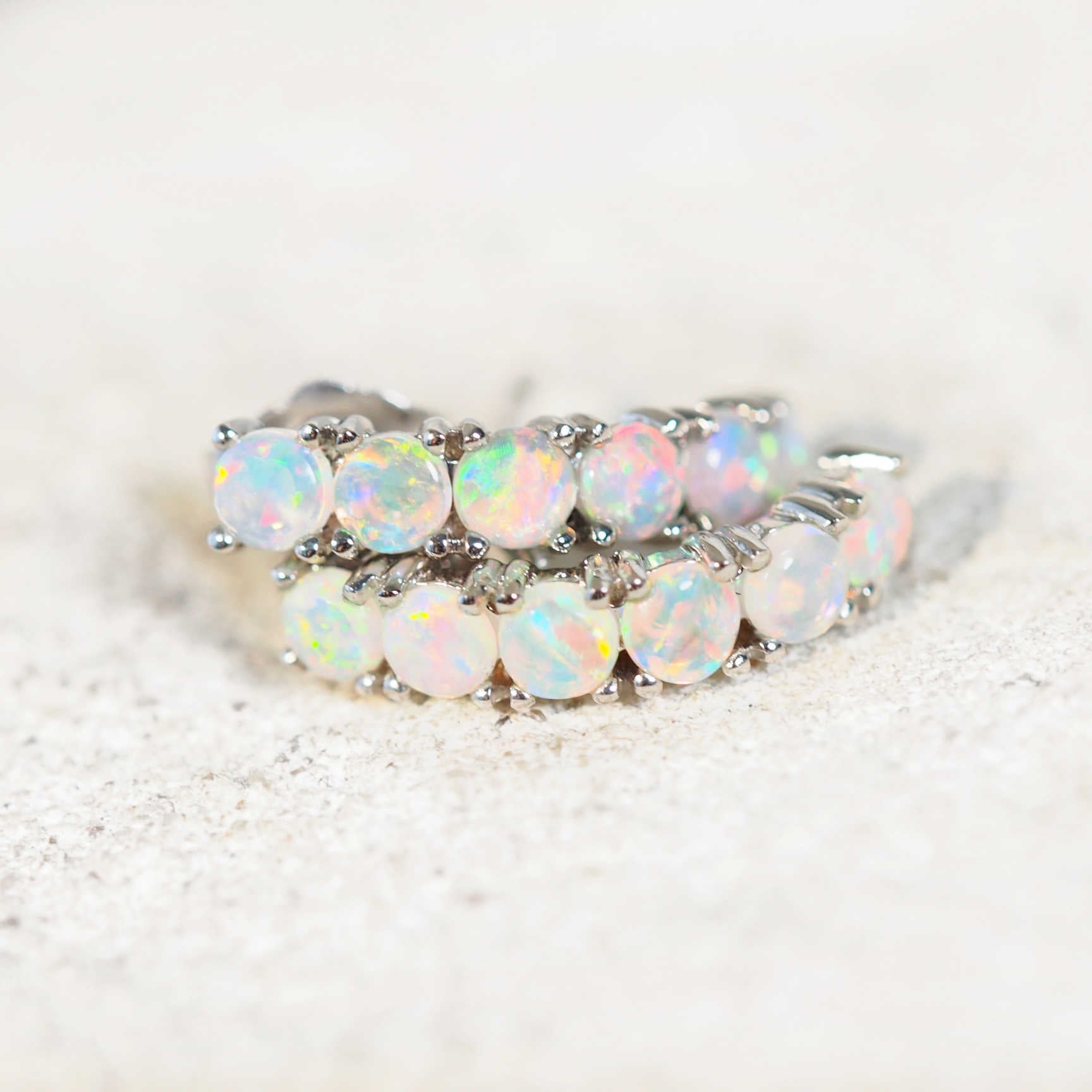 a pair of opal earrings set in white gold