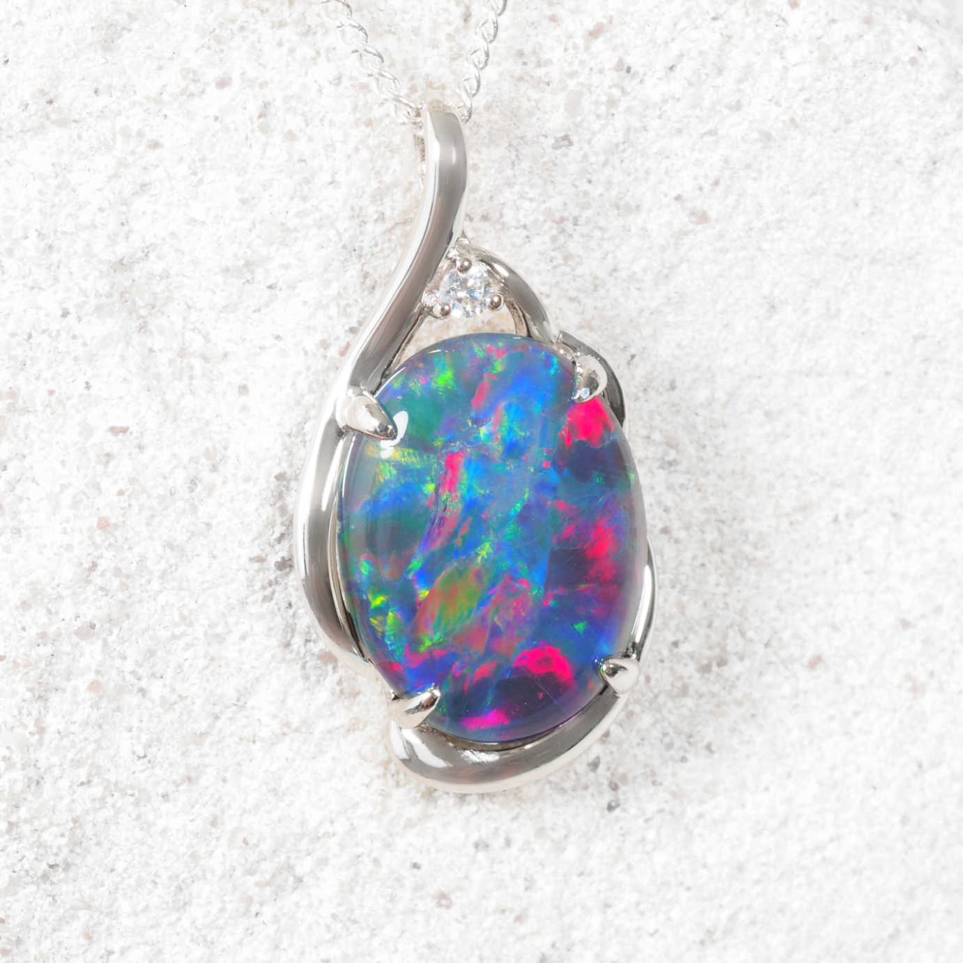 Opal pendant with silver setting on a white background