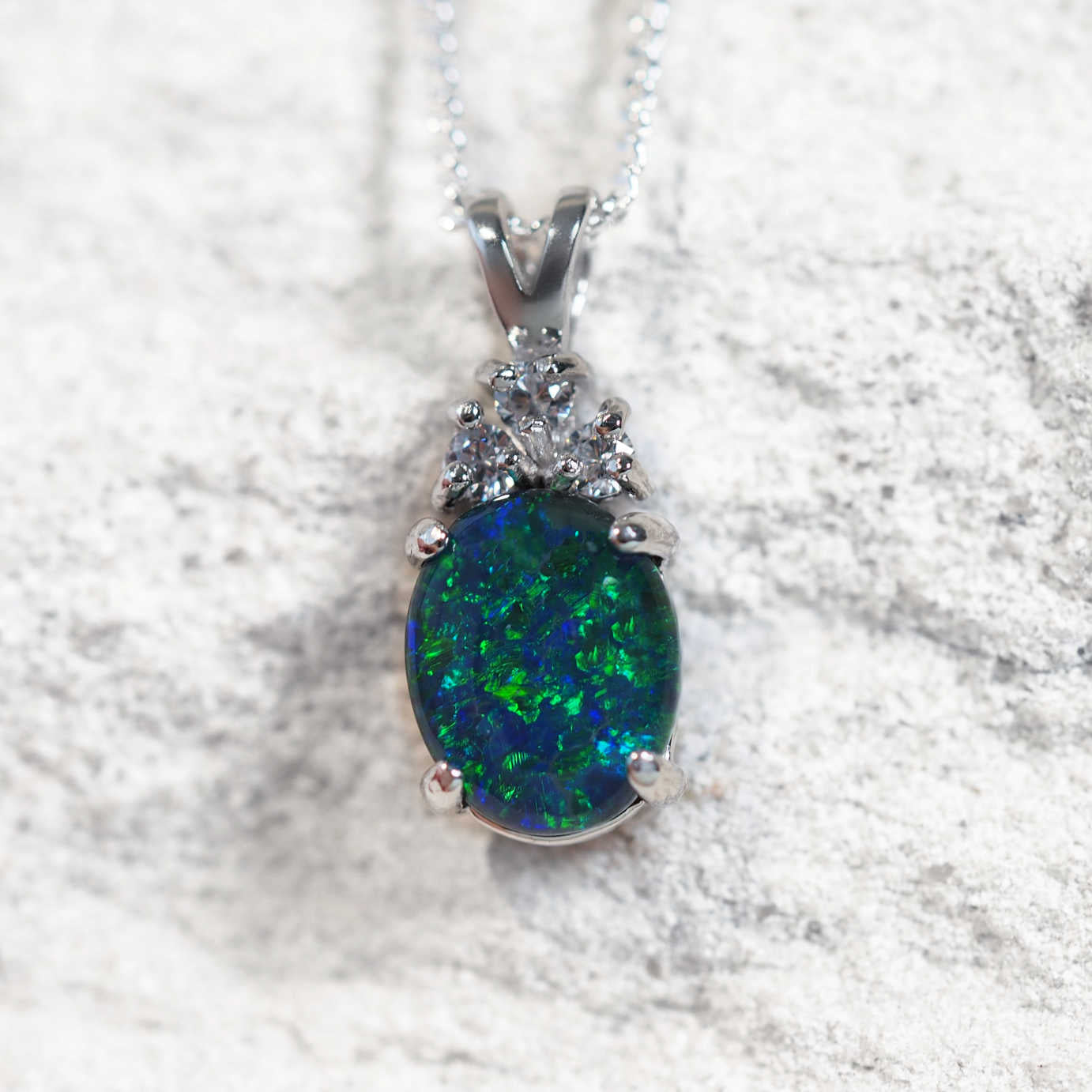 The ‘Trinity Blue Midi’ opal pendant in sterling silver features a blue-green Australian triplet opal with three cubic zirconias.
