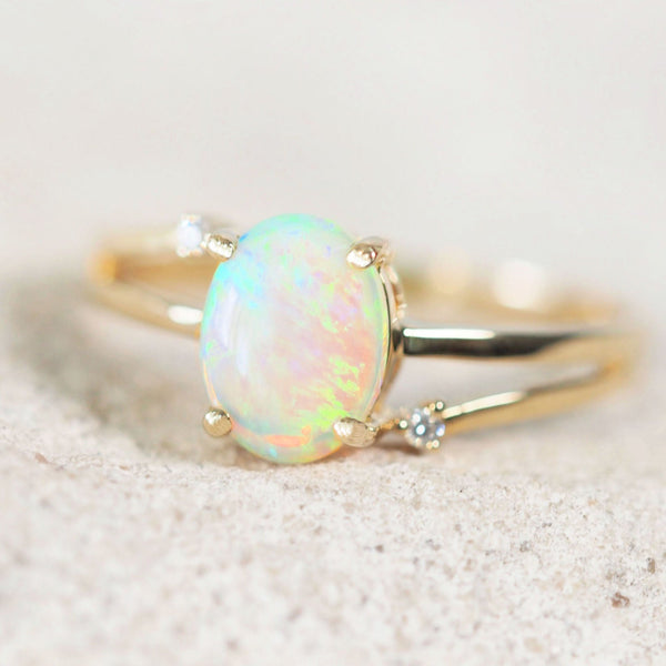 green oval Australian crystal opal set in a 14ct yellow gold ring with two diamonds