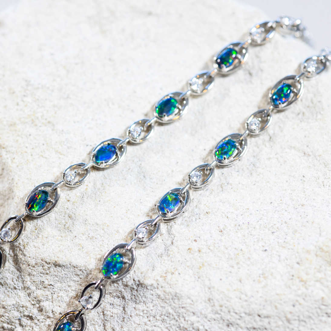 'Classic Link' opal bracelet in sterling silver with five claw-set oval Australian triplet opals in vivid blue and green tones and 16 sparkling crystals