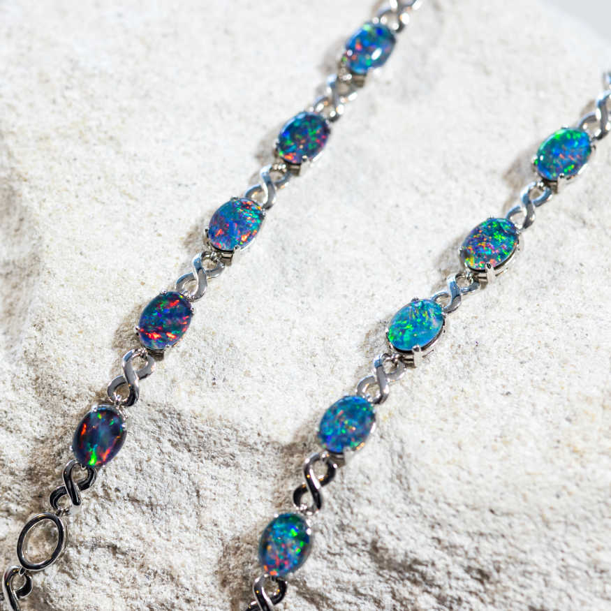 Eternity opal bracelet in sterling silver with adjustable eternity design and five claw-set oval Australian triplet opals in multi-coloured tones