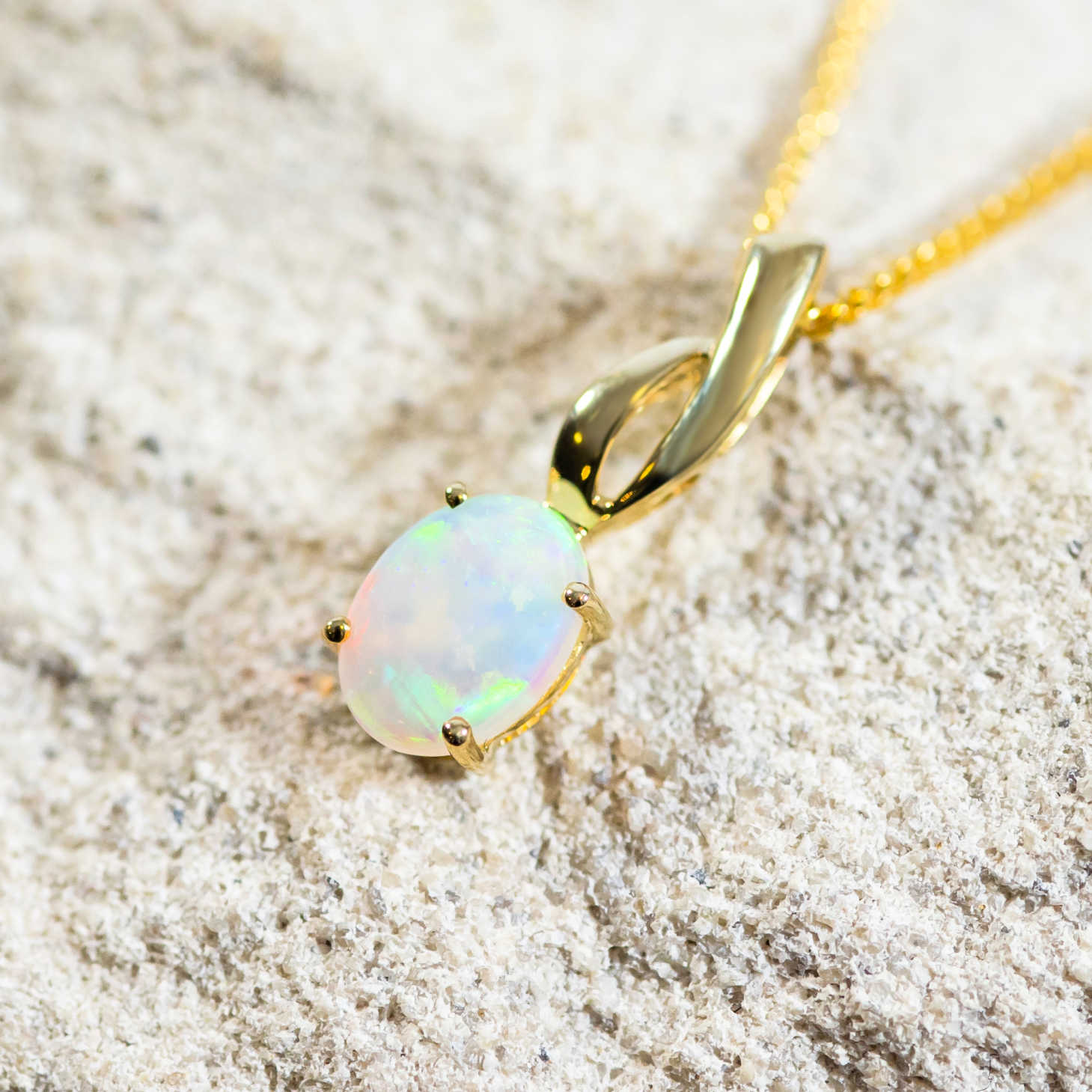 white opal set into a 9ct gold pendant