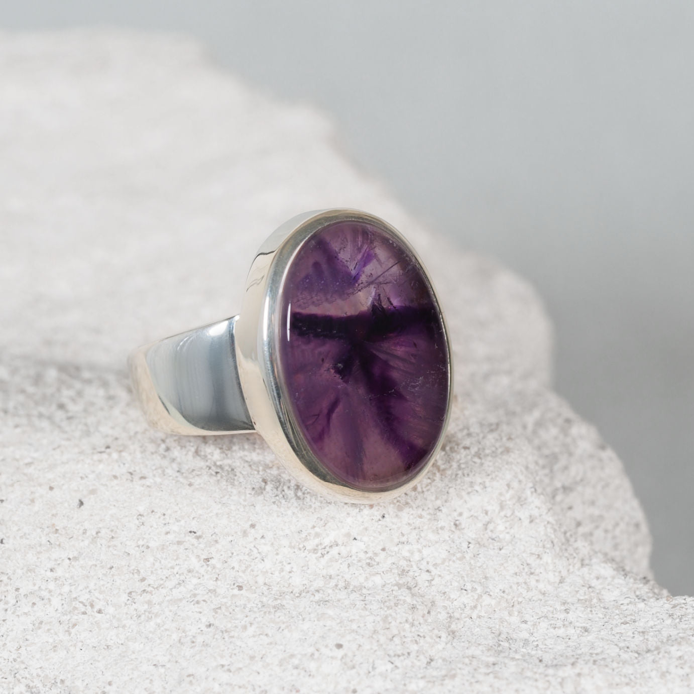 Crafted silver ring, ‘Kaylee,’ with a smooth oval amethyst cabochon featuring blended purple colours