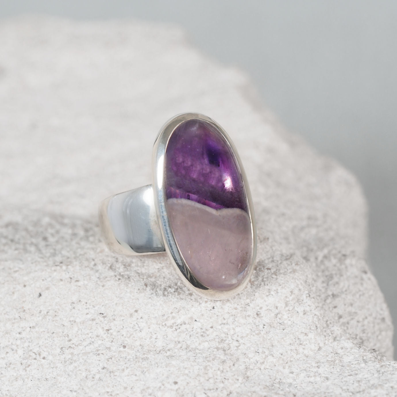 The 'Sabrina' Silver Amethyst Ring displaying light clear hues in the bottom part and dark yet light purple in the top half