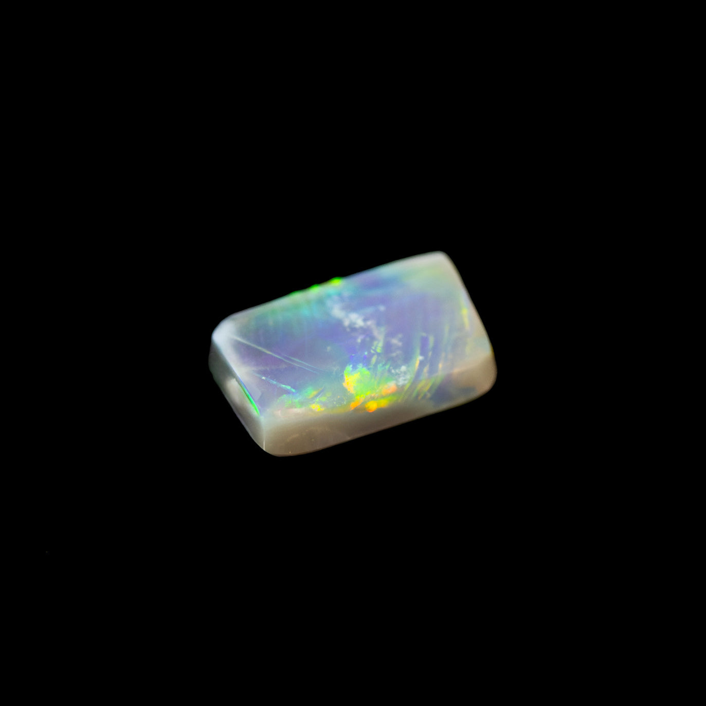 Natural solid Lightning Ridge opal gemstone showing neon green flashes across charcoal base