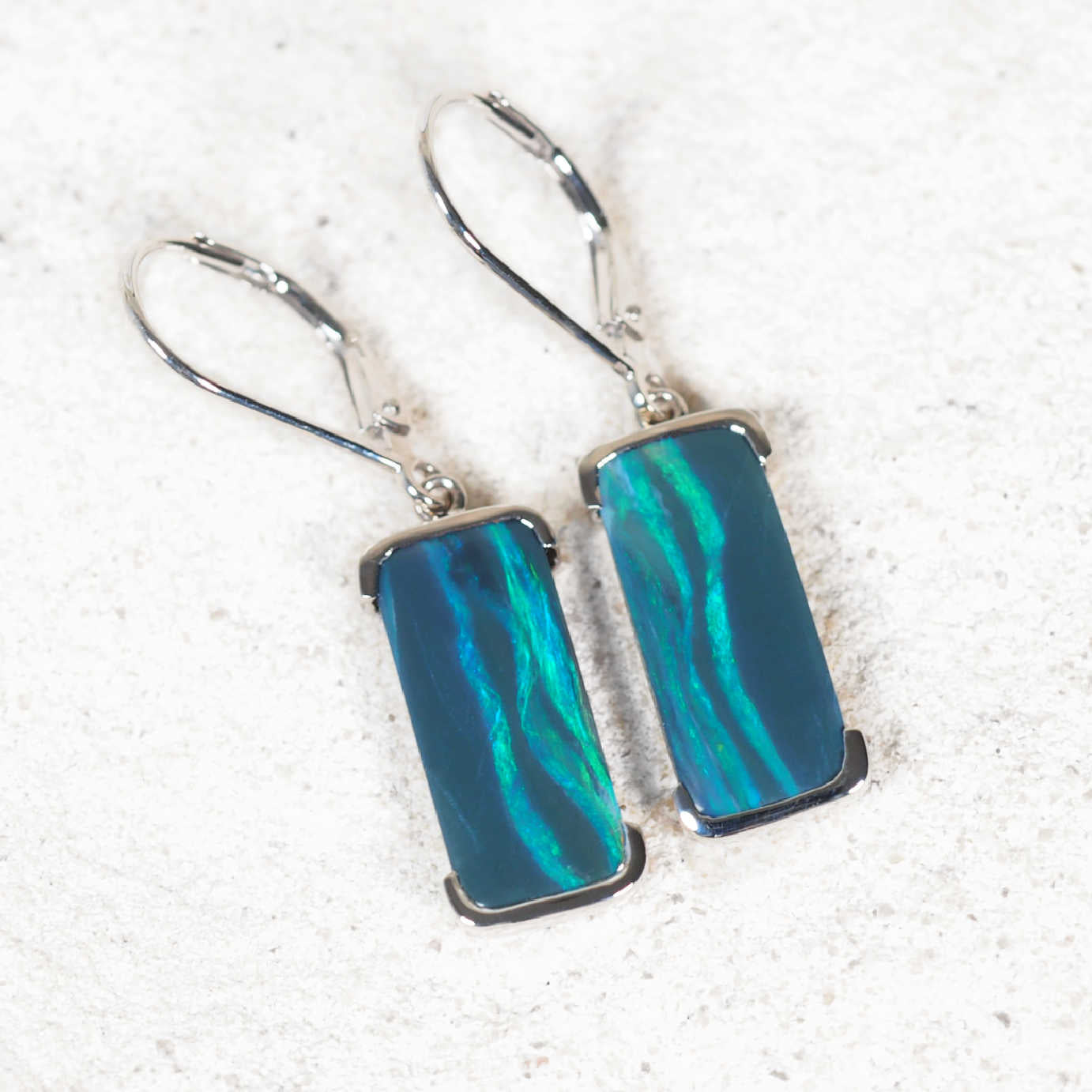 'Corinna' black opal drop earrings in 14ct white gold featuring rectangular Lightning Ridge opals with vivid green flashes