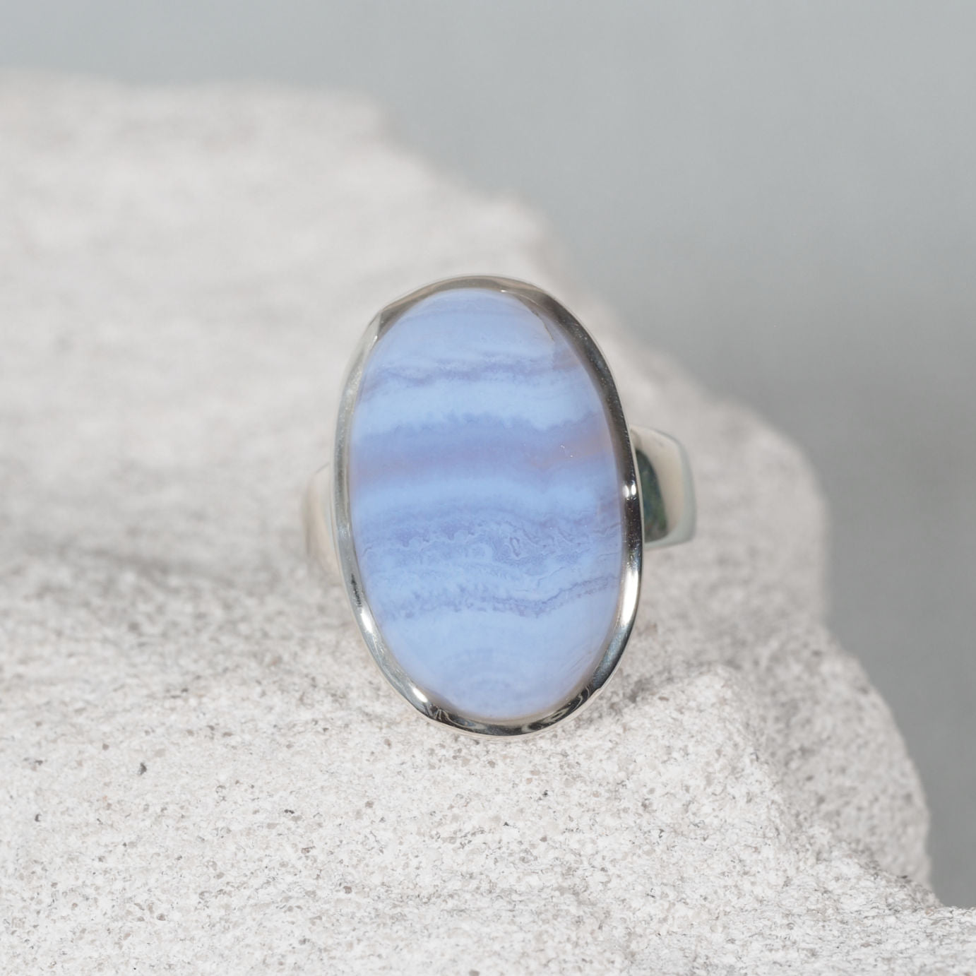 The ‘Iris’ ring highlights an oval Blue Lace Agate gemstone in a silver setting, combining serene colours with graceful style
