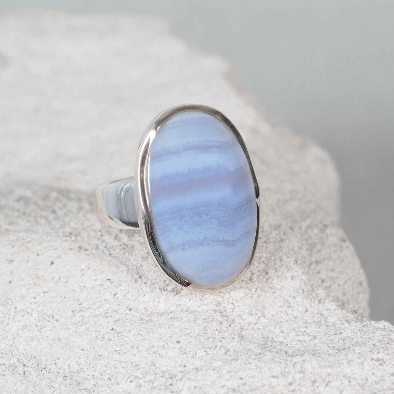 Polished silver ring ‘Iris’ featuring an oval Blue Lace Agate cabochon with gentle blue tones and natural white veining