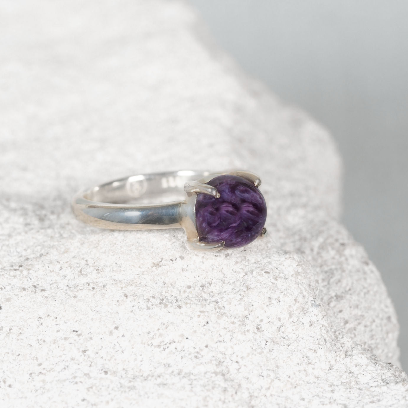 Petite round Charoite ring in polished silver with claw and bezel setting, showing deep purple and lavender tones