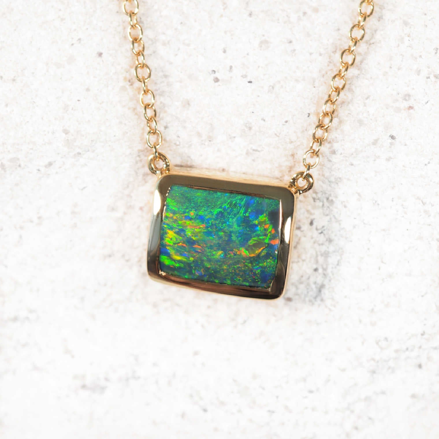 Luxury Australian black opal necklet featuring bezel-set rectangular opal in 14ct yellow gold adjustable chain with diamonds