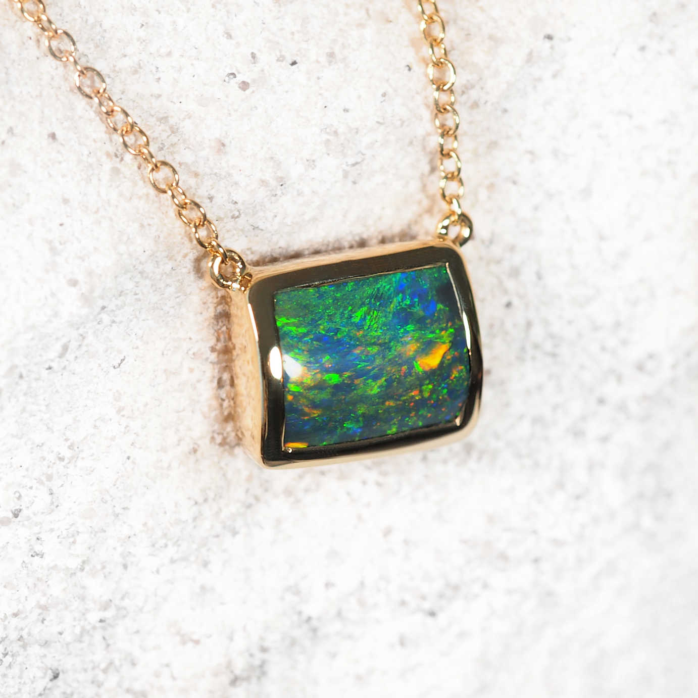 Emmella black opal necklet in 14ct yellow gold with rectangular Lightning Ridge opal and two diamond accents