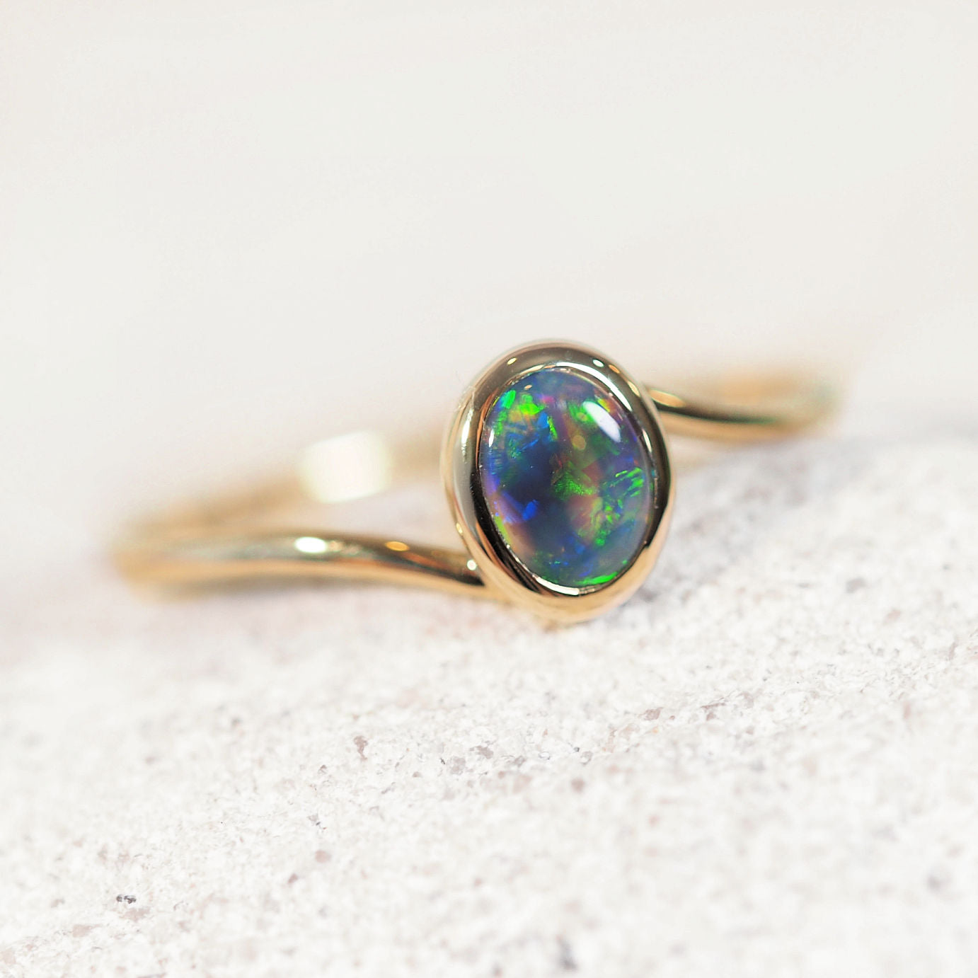 Black opal gold ring on a light background