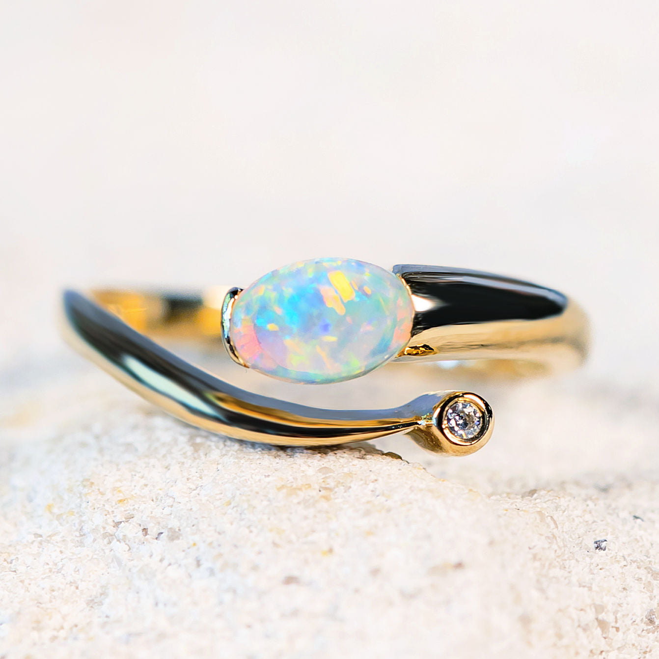colourful oval shaped crystal opal gold ring with one sparkling diamond