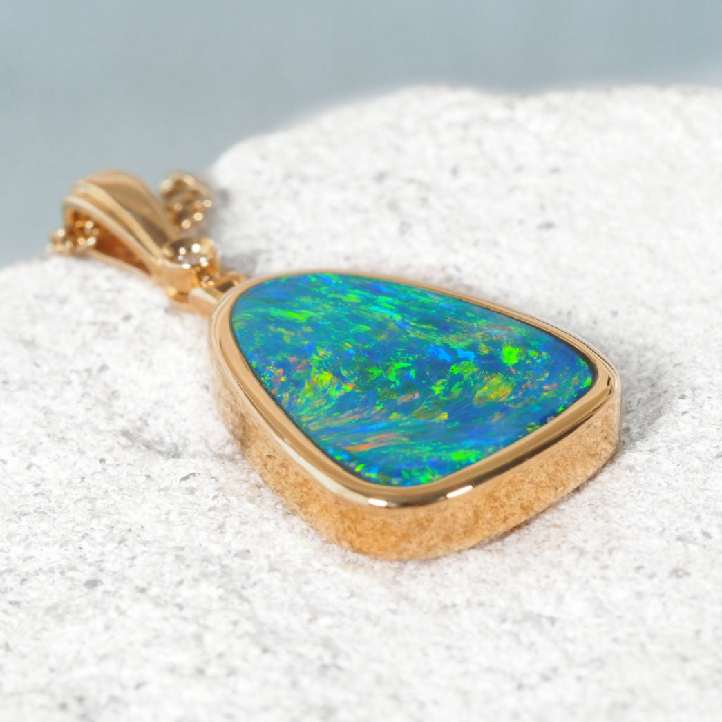 Handcrafted 14ct gold pendant with vibrant triangular opal and white diamond.