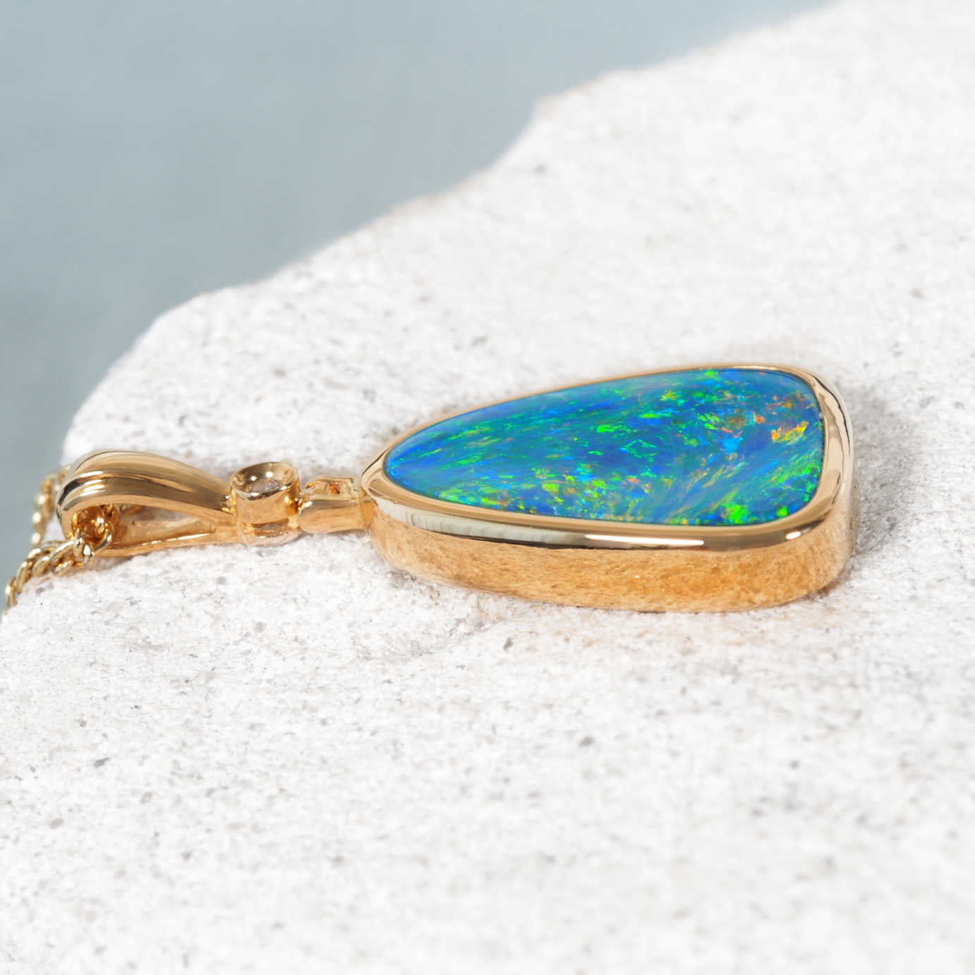 Luxury gold opal and diamond necklace featuring a bezel-set triangular opal