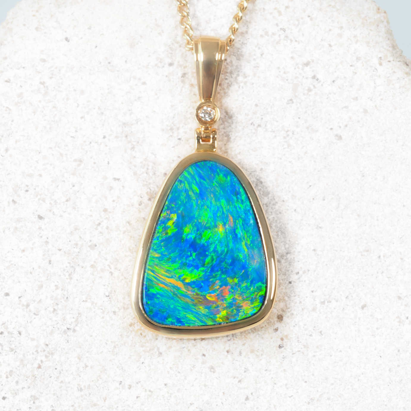 Triangular Australian doublet opal pendant in 14ct yellow gold with diamond accent