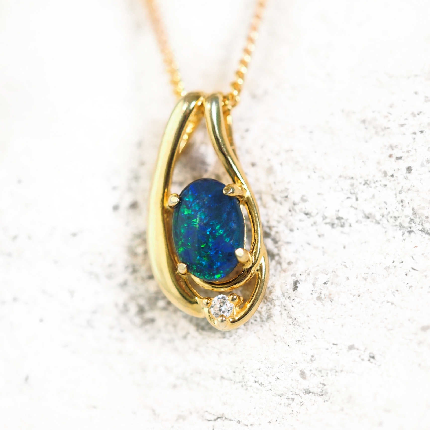Gold-plated silver opal necklace pendant with claw-set blue and green Australian triplet opal and one cubic zirconia, shown with matching chain.