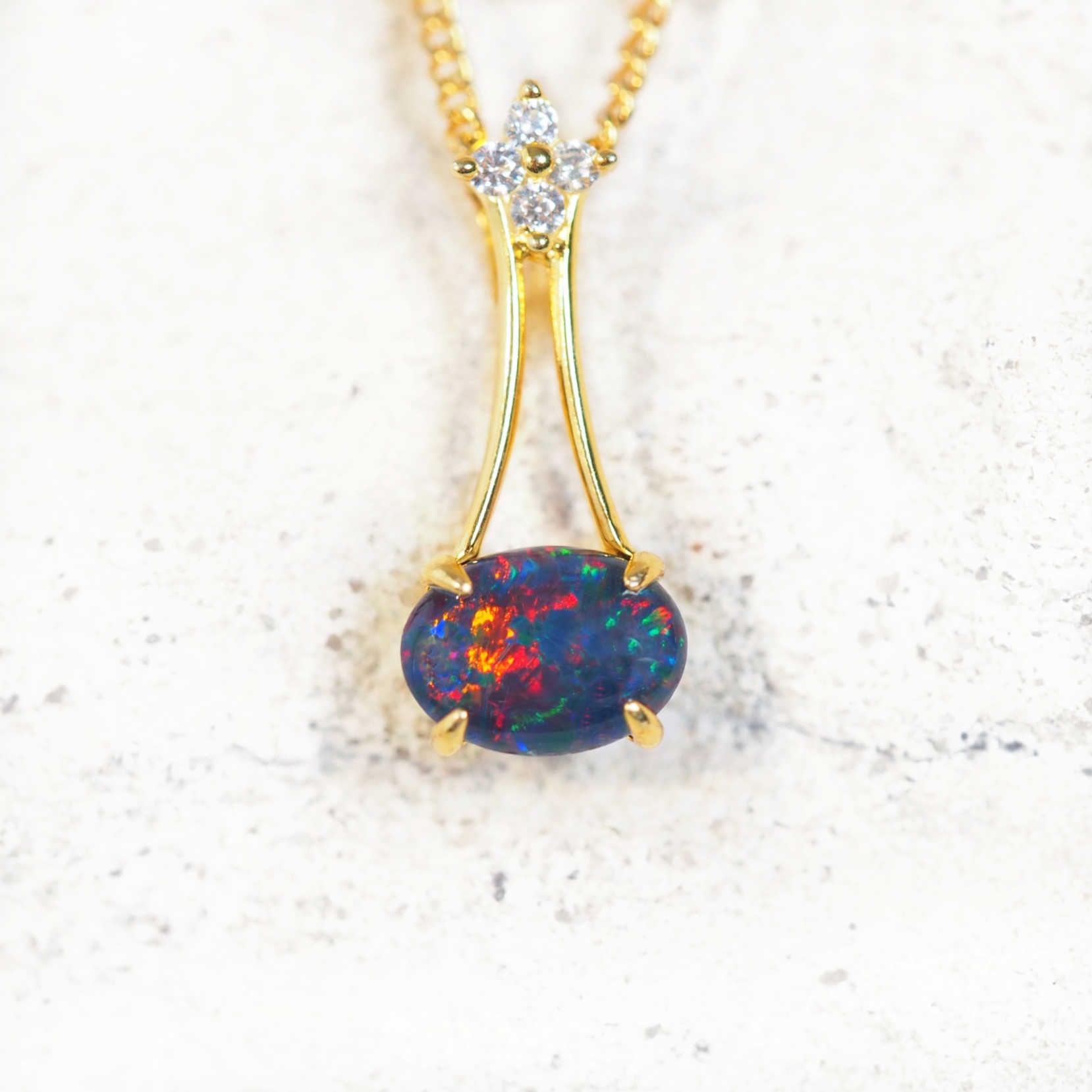 Gold-plated silver opal pendant with sideways-set Australian triplet opal and cubic zirconia flower design