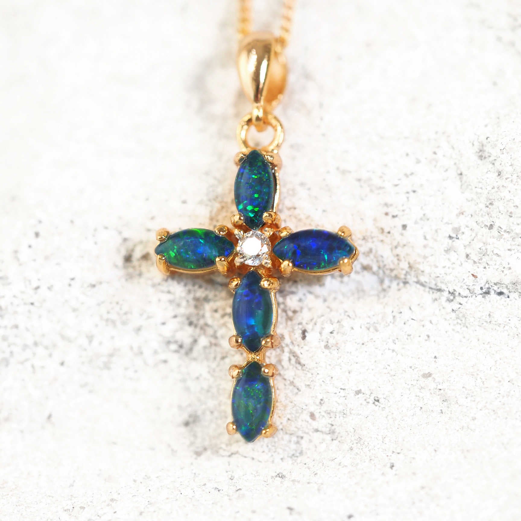 Gold-plated silver cross pendant with five blue-green Australian triplet opals and a central cubic zirconia.