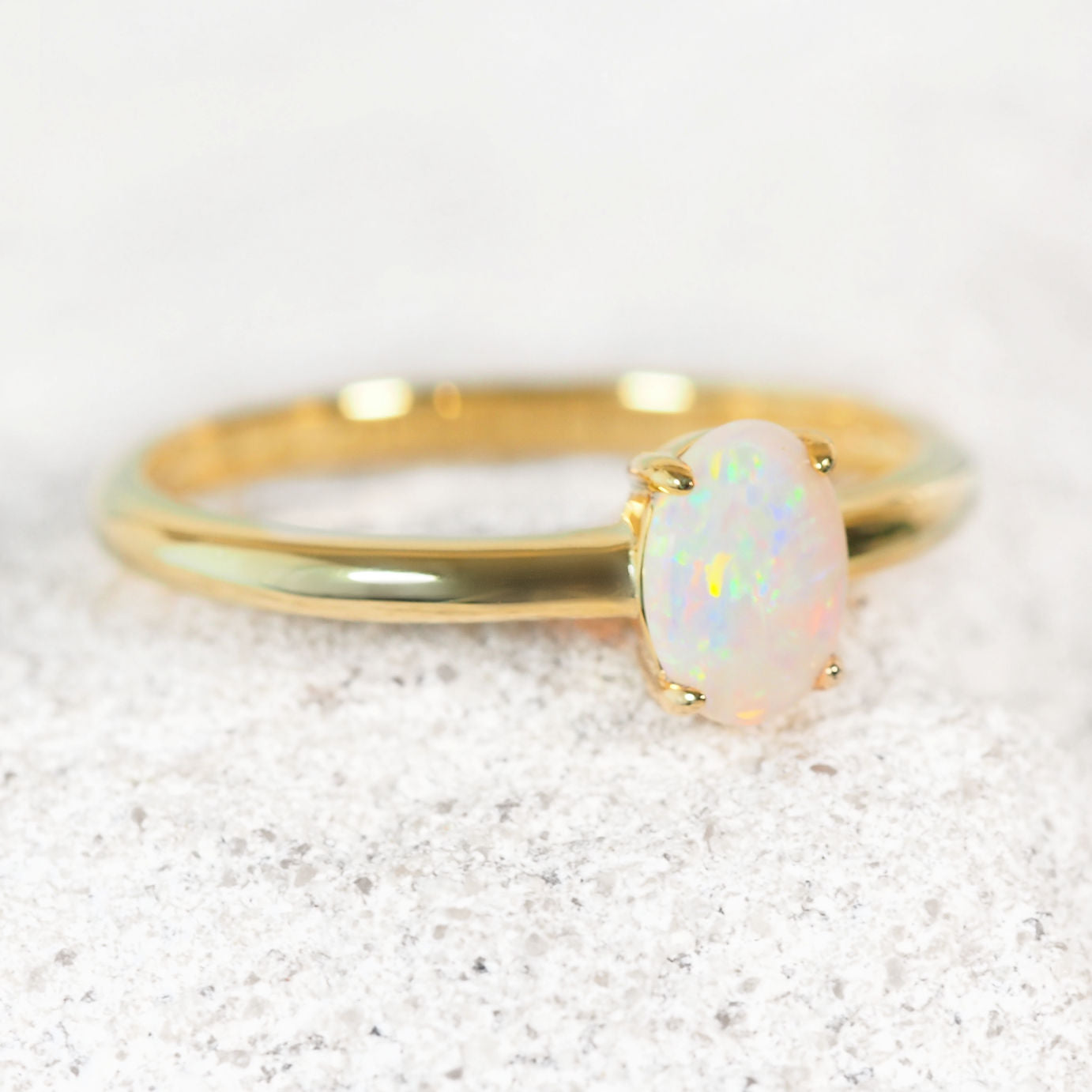 Elegant gold plated silver opal ring featuring oval-shaped South Australian solid white opal with radiant multi-coloured flashes