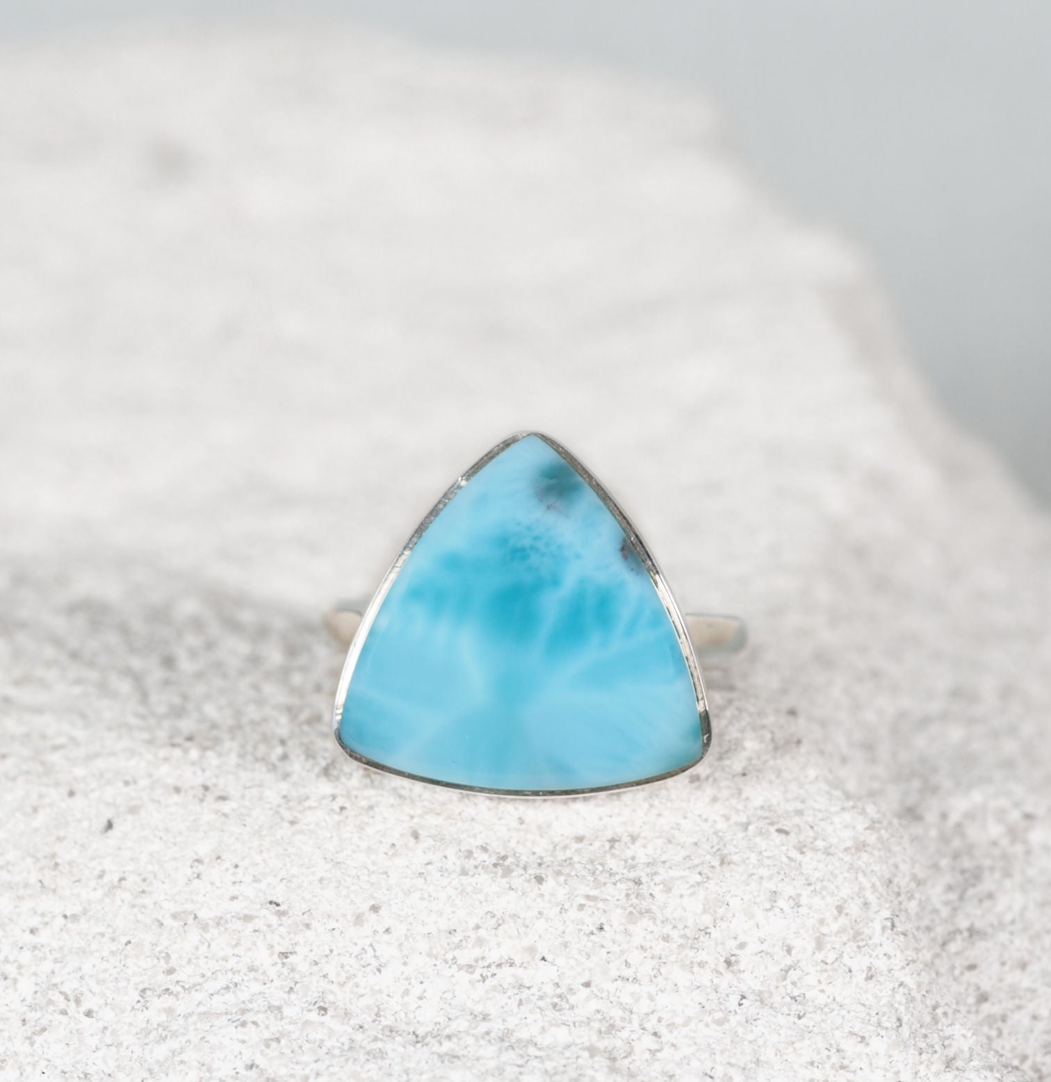 Larimar Silver Ring on a sandy background displaying blue bright tones
