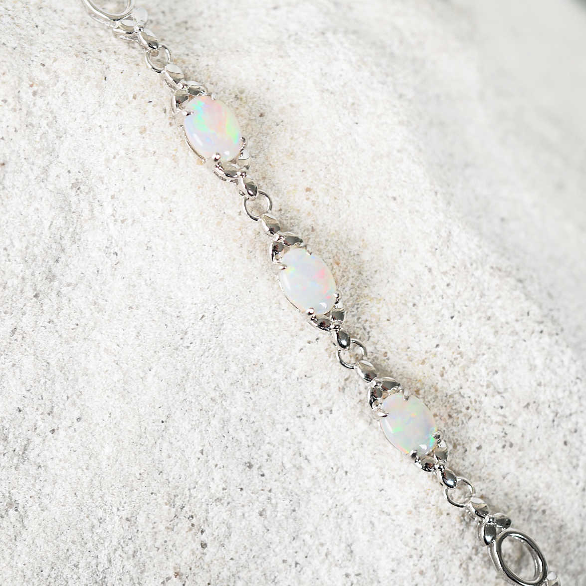 Silver bracelet with opal beads on a sandy background